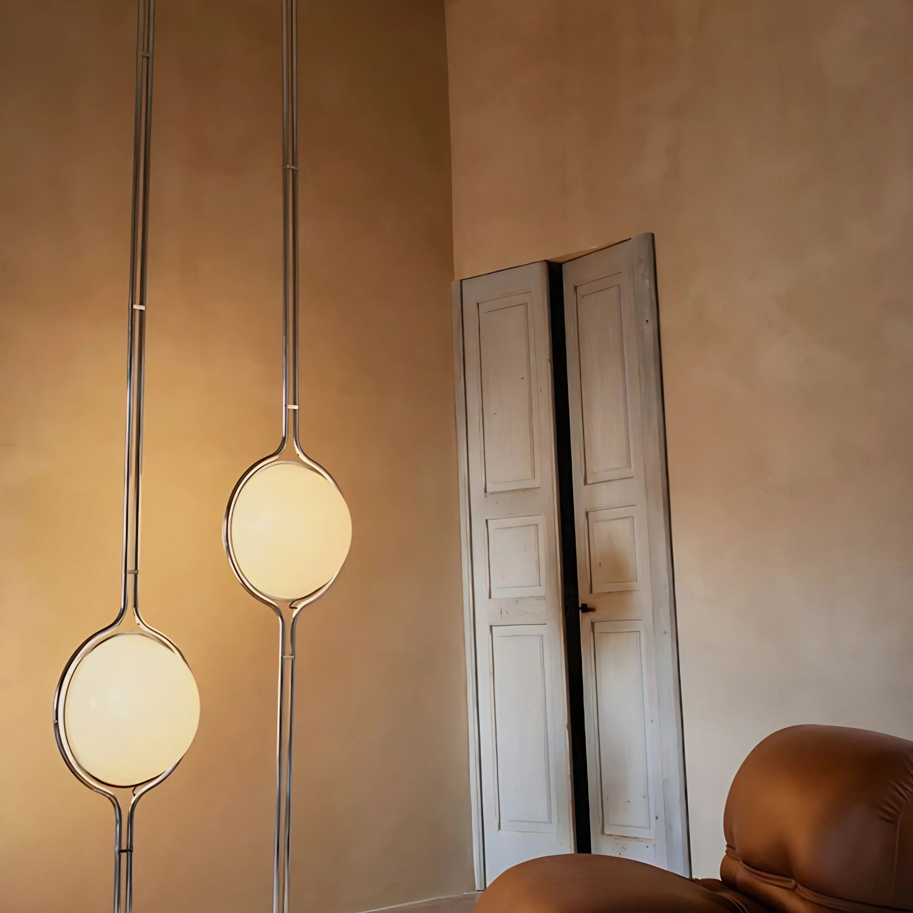 Chrome Sfera Sospesa floor-to-ceiling globe lamp in a warm living room