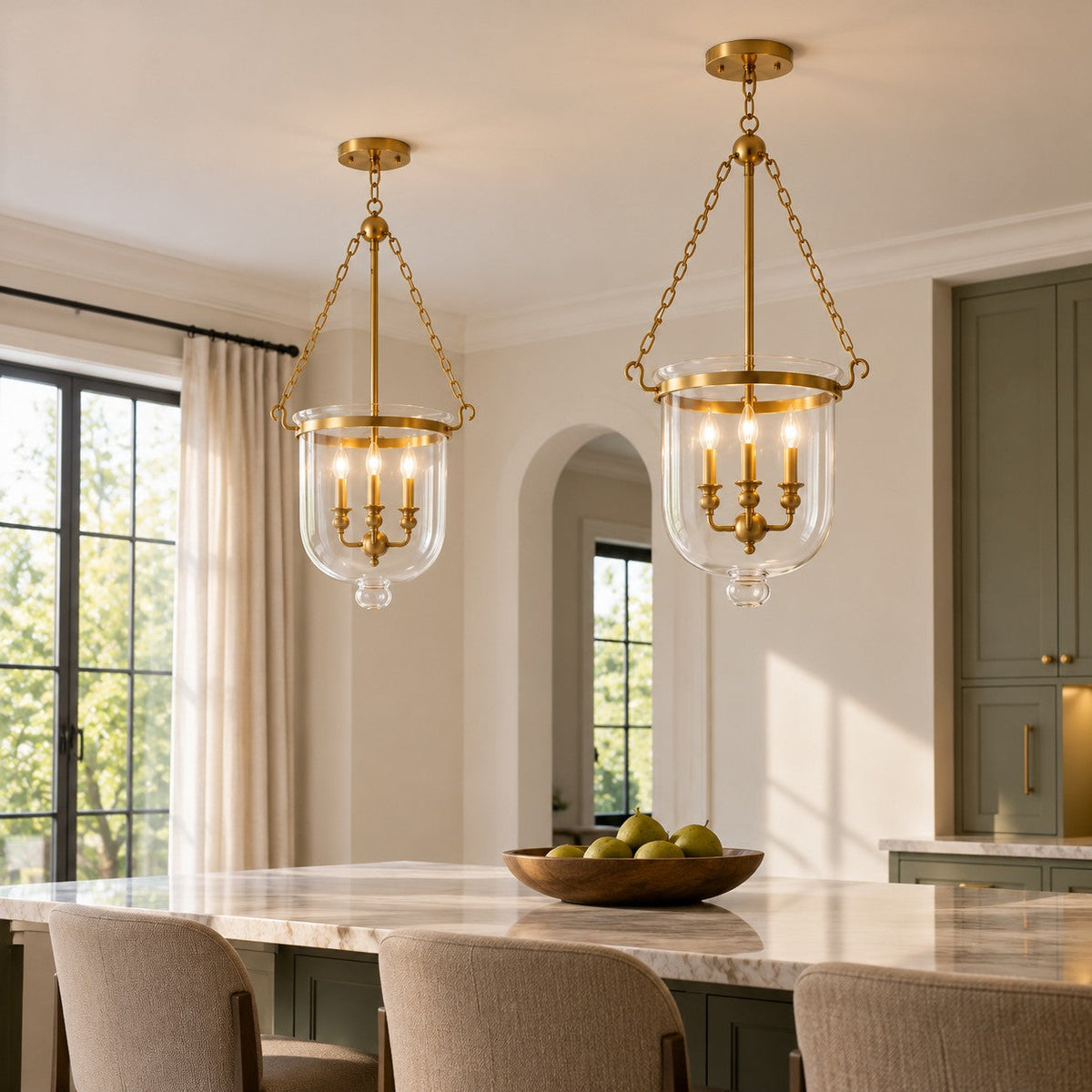 Pair of brass bell jar pendants over a kitchen island