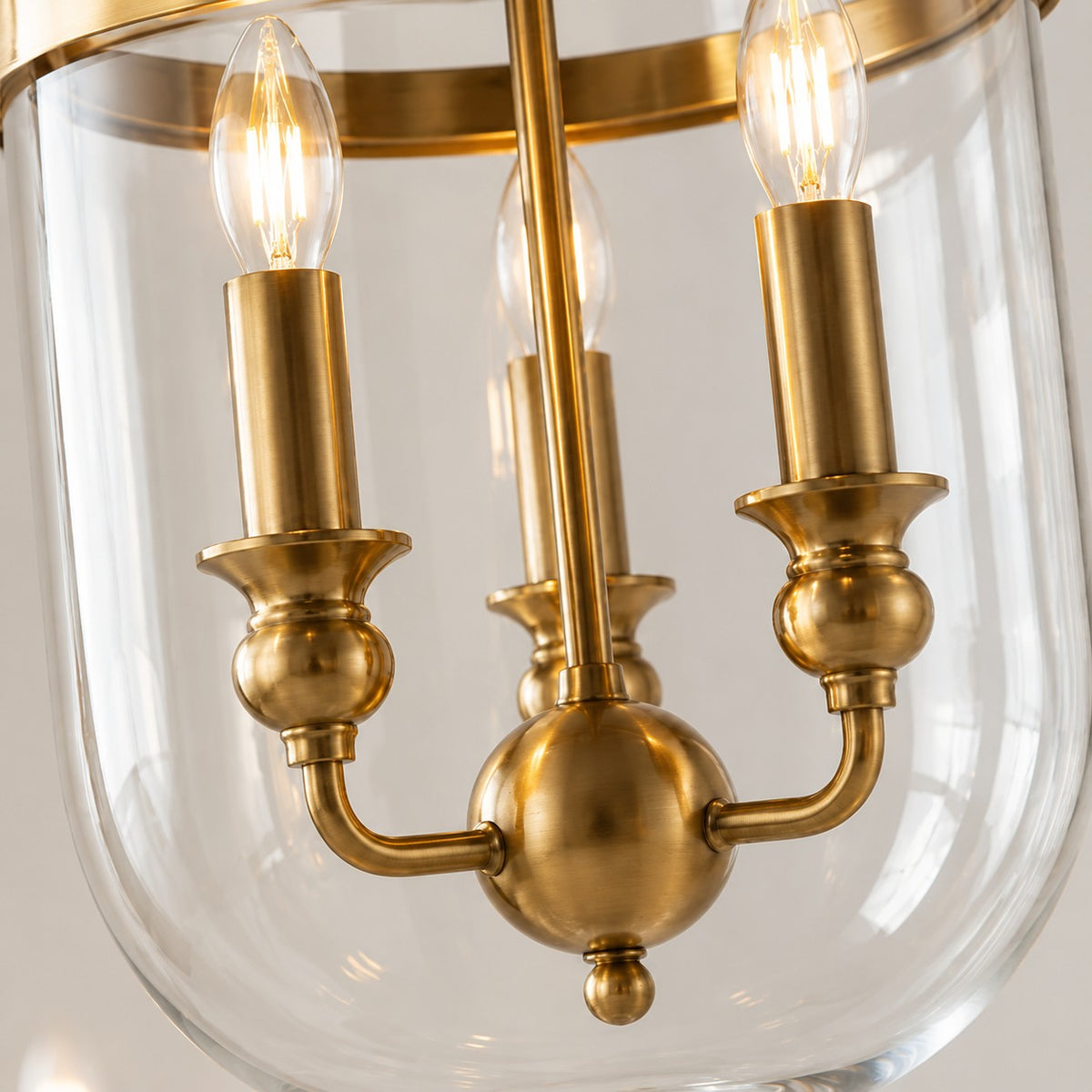 Brass candelabra cluster inside the clear glass bell jar