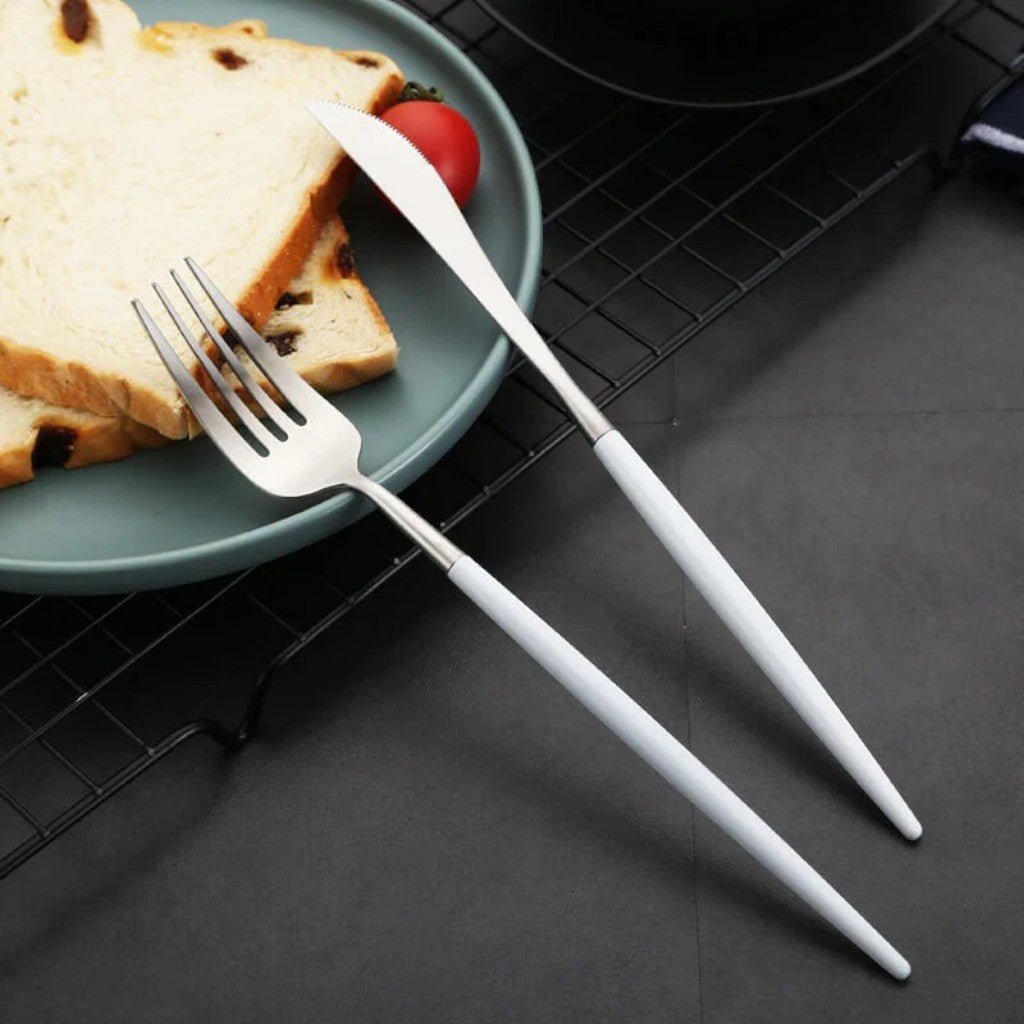 White and silver cutlery on a grey plate