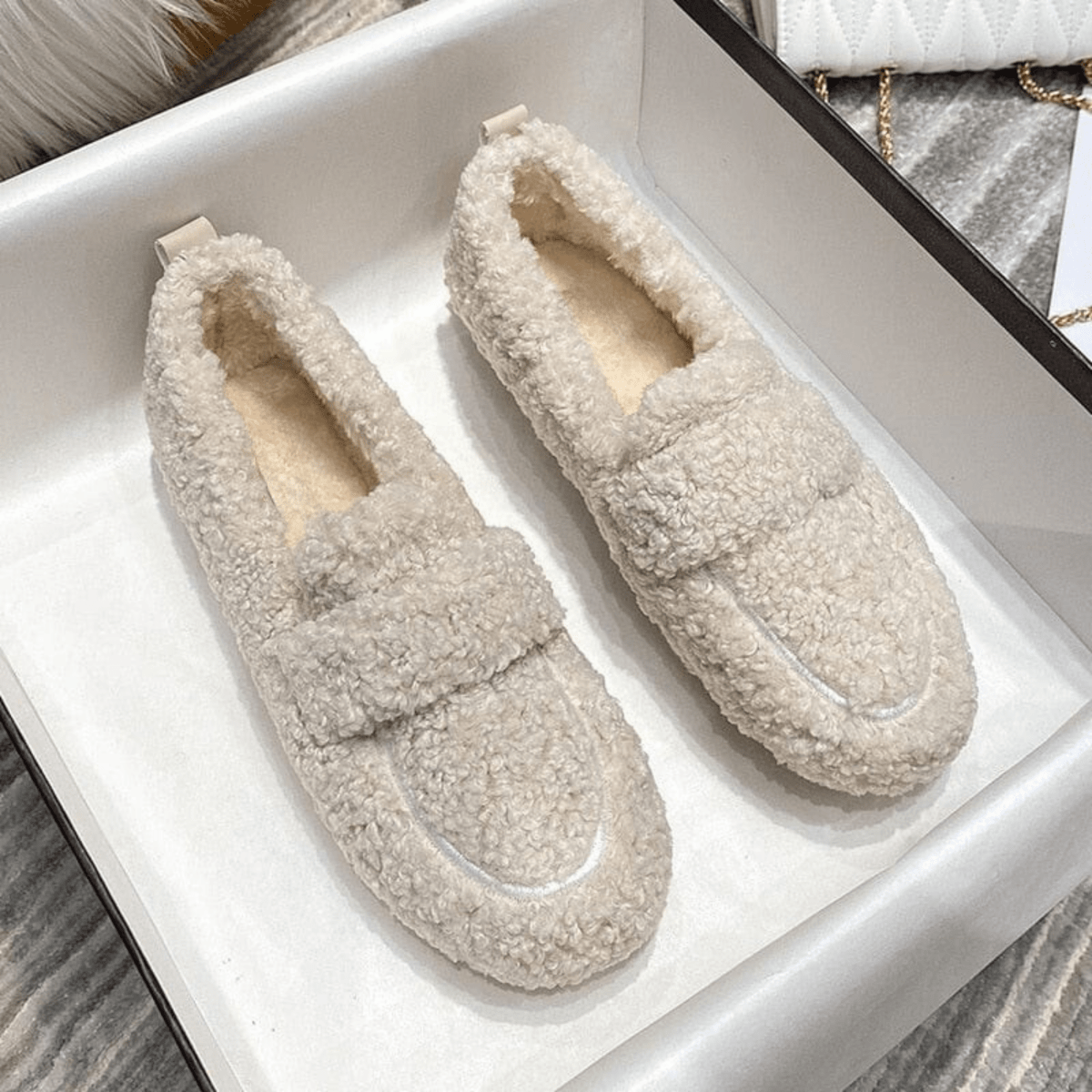 Beige plush teddy slippers styled in a tray