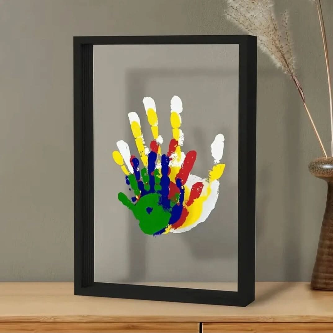 Black keepsake frame with a baby handprint on a console