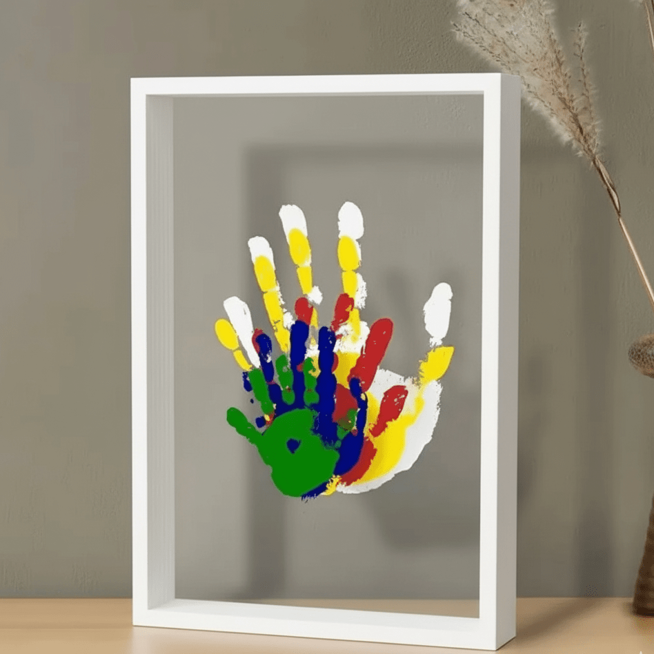 White keepsake frame with a baby handprint on a console