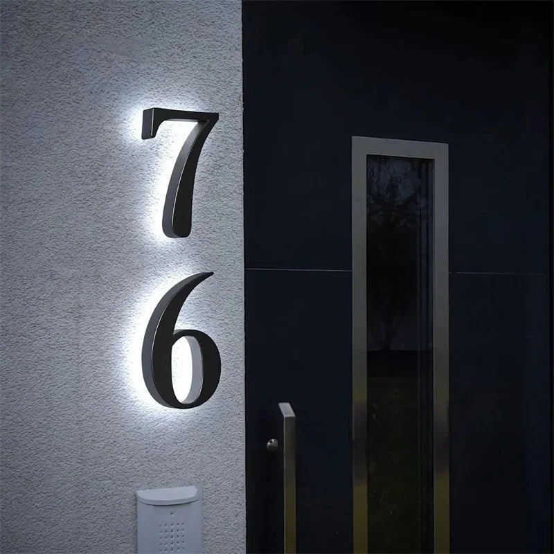 Illuminated house number 76 in white on a modern facade