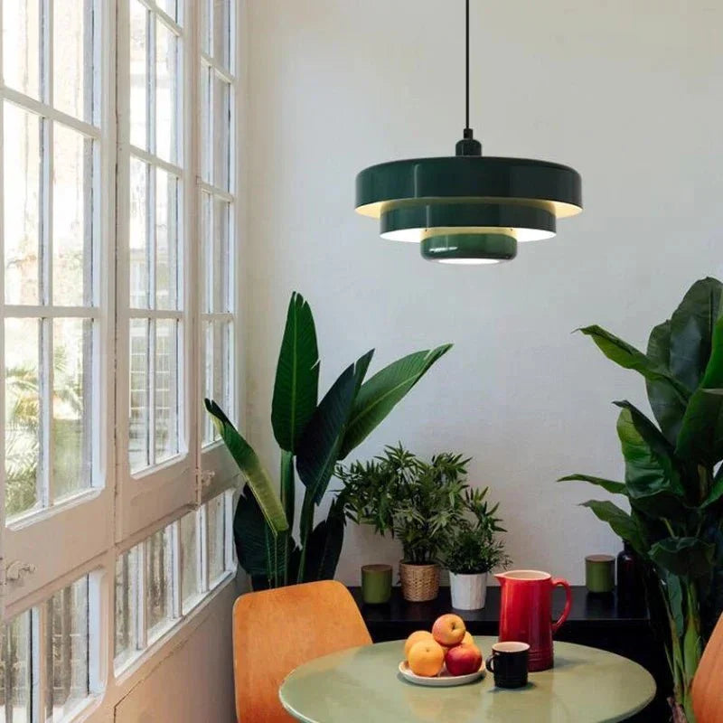 Green macaron pendant light in a bright dining nook by a window