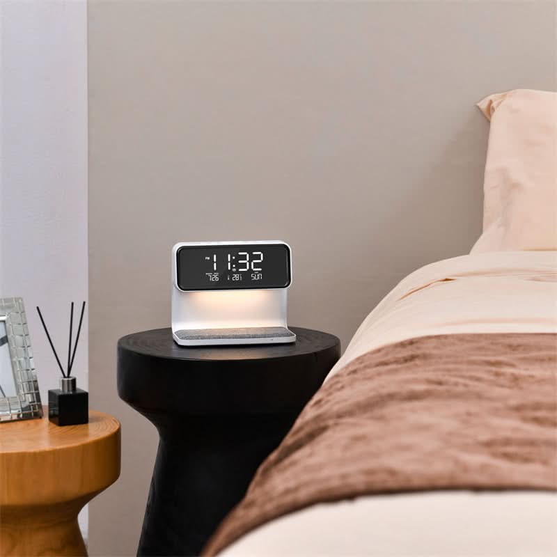 Aurora 3-in-1 station on a black side table beside a neutral bed