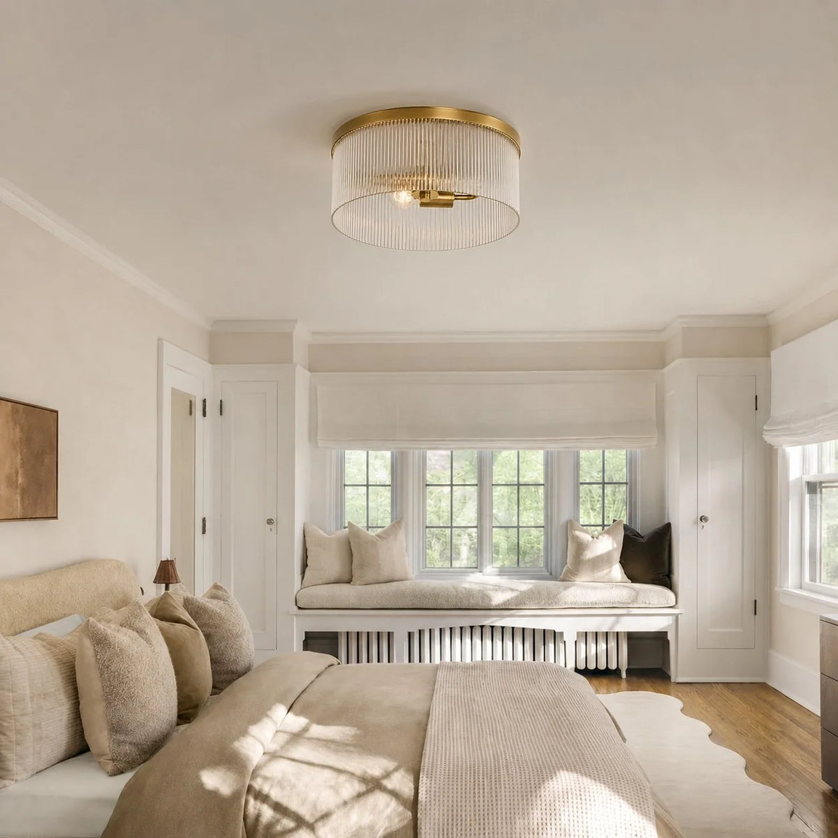 Tumbled brass ribbed glass flush mount in a bright cream bedroom with window seat