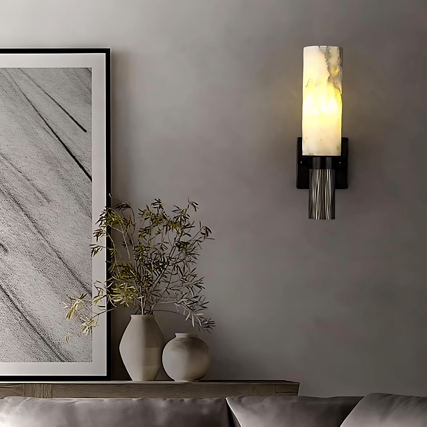 Aurora Marble Wall Sconce above a console with framed art and vases