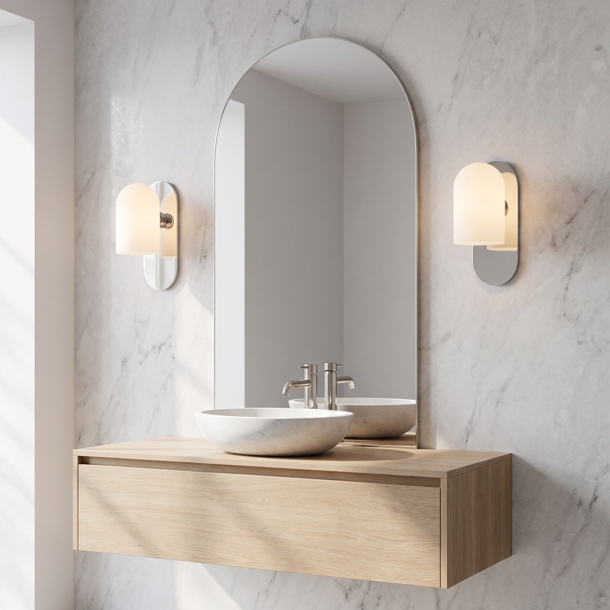 Pair of Capsula Opalina opal glass wall sconces in nickel either side of an arched bathroom mirror