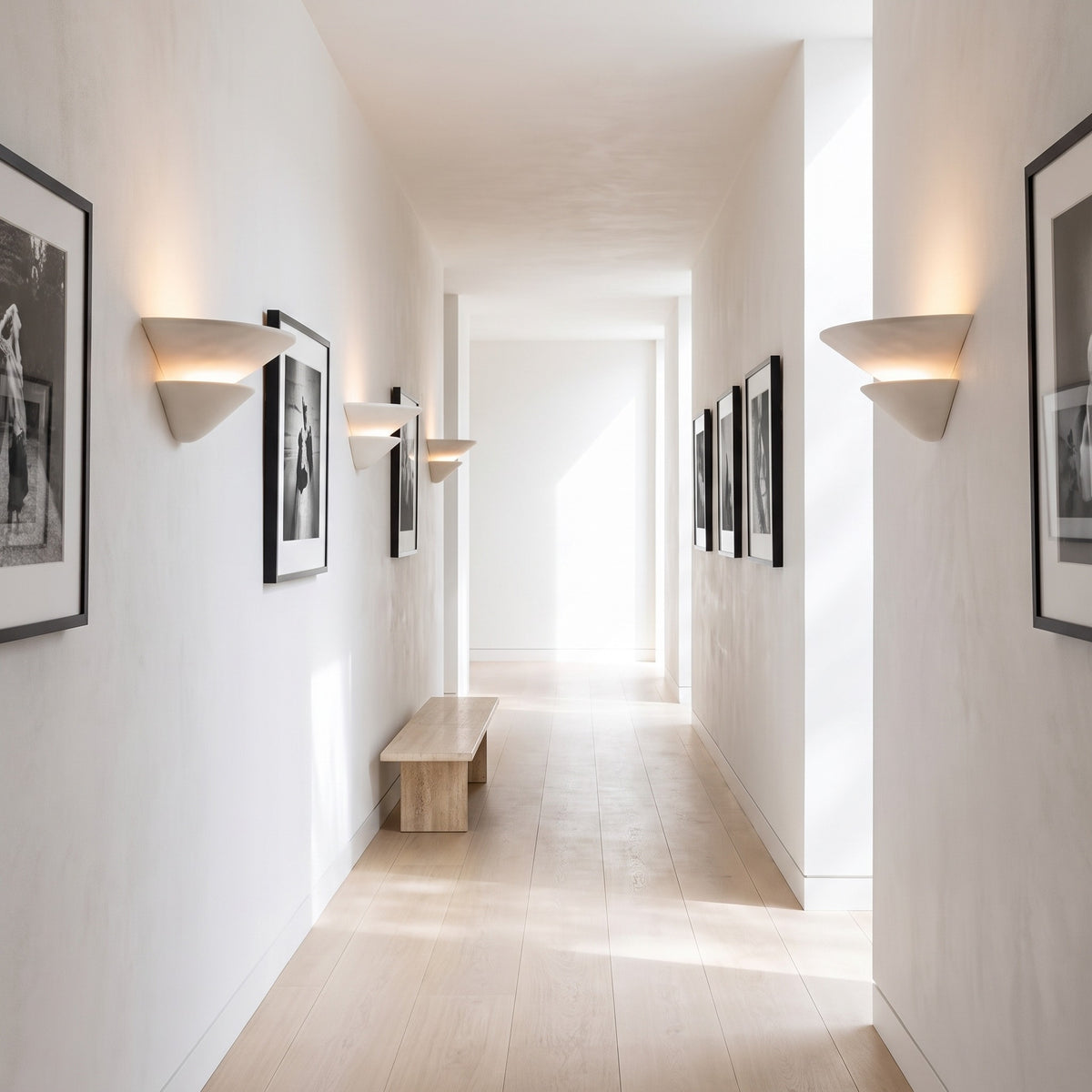 Coppa Serena alabaster wall sconces lining a bright gallery hallway