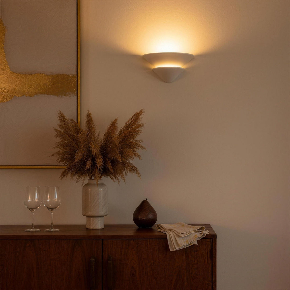 Coppa Serena alabaster wall sconce glowing above a walnut sideboard