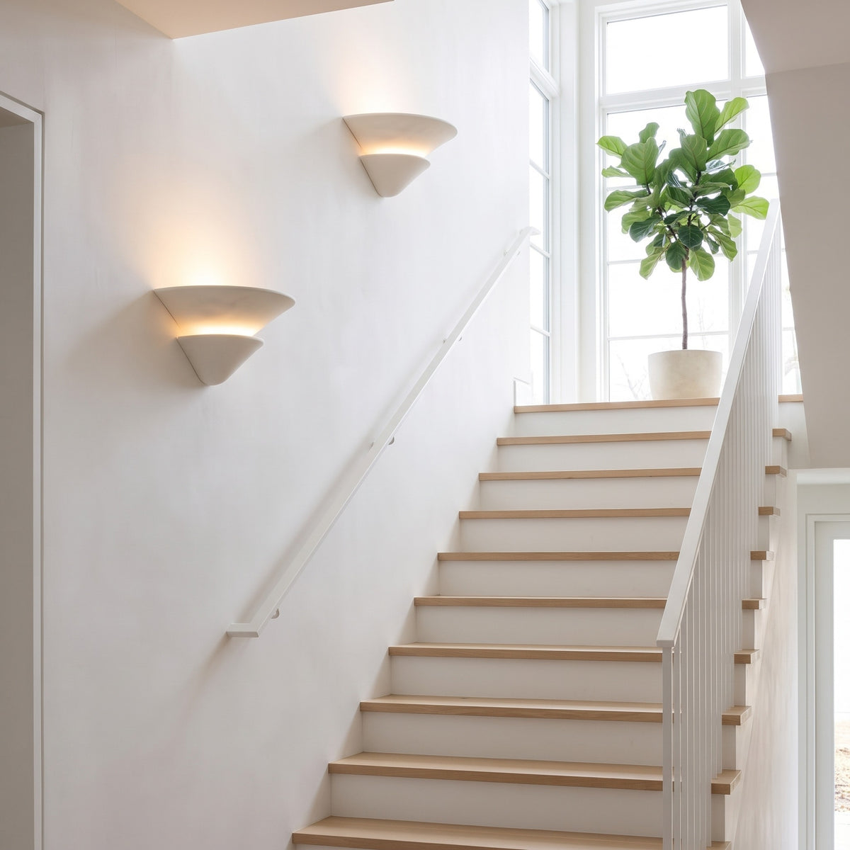 Coppa Serena alabaster wall sconces stepping up a bright oak staircase