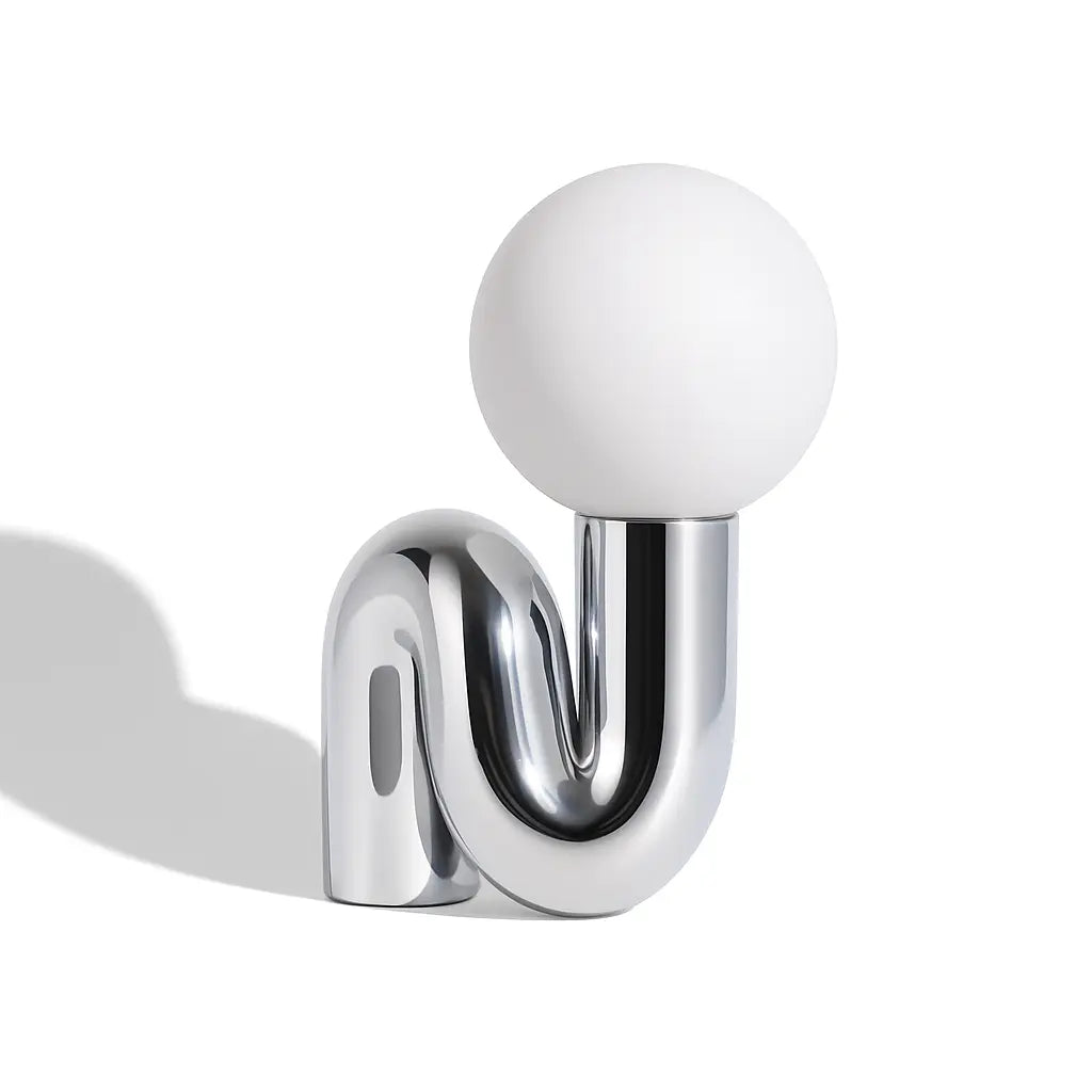 Ricciolo Lucente chrome sculptural table lamp — full studio view on white