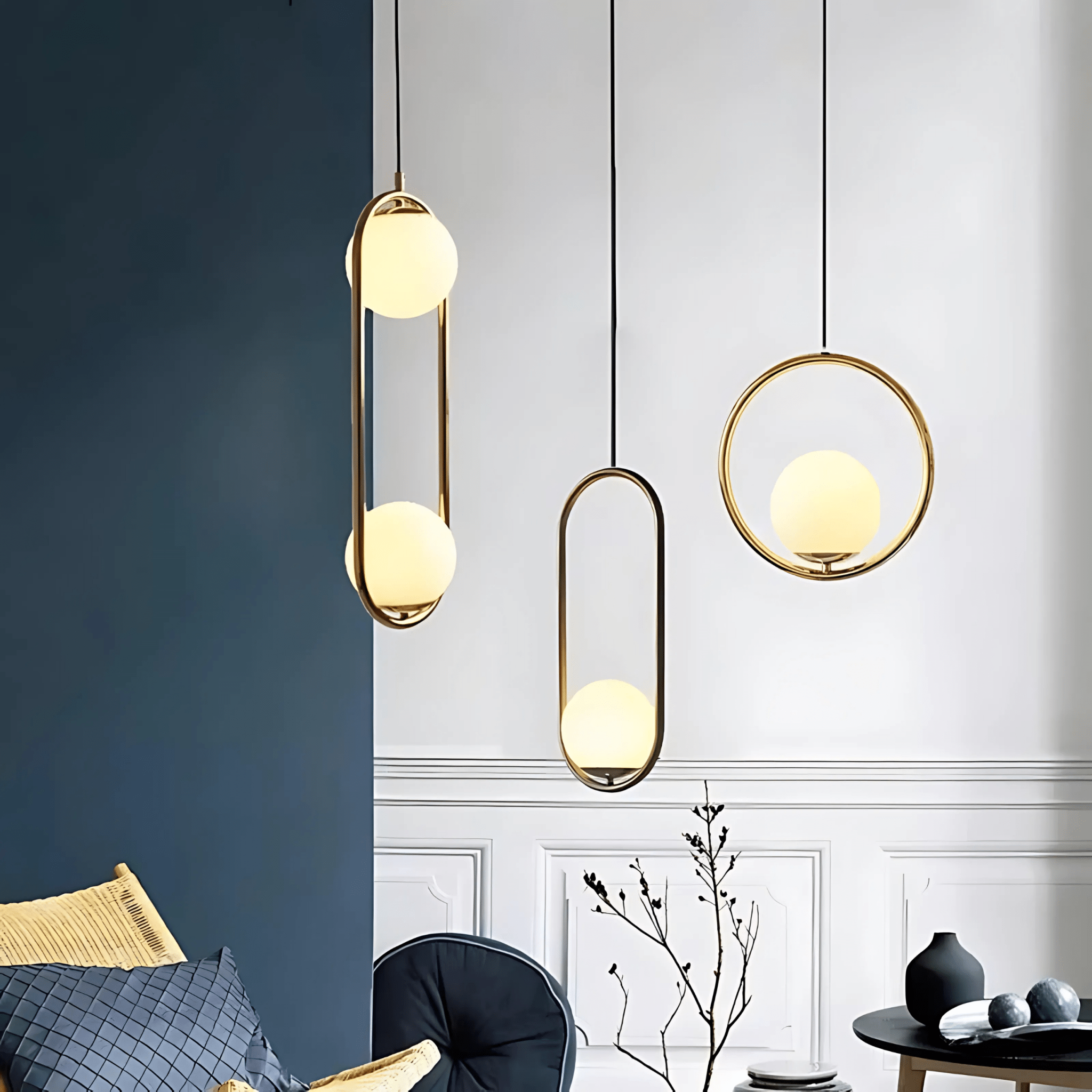 Three brass Sfera glass-globe pendants against a deep blue wall in a styled living room