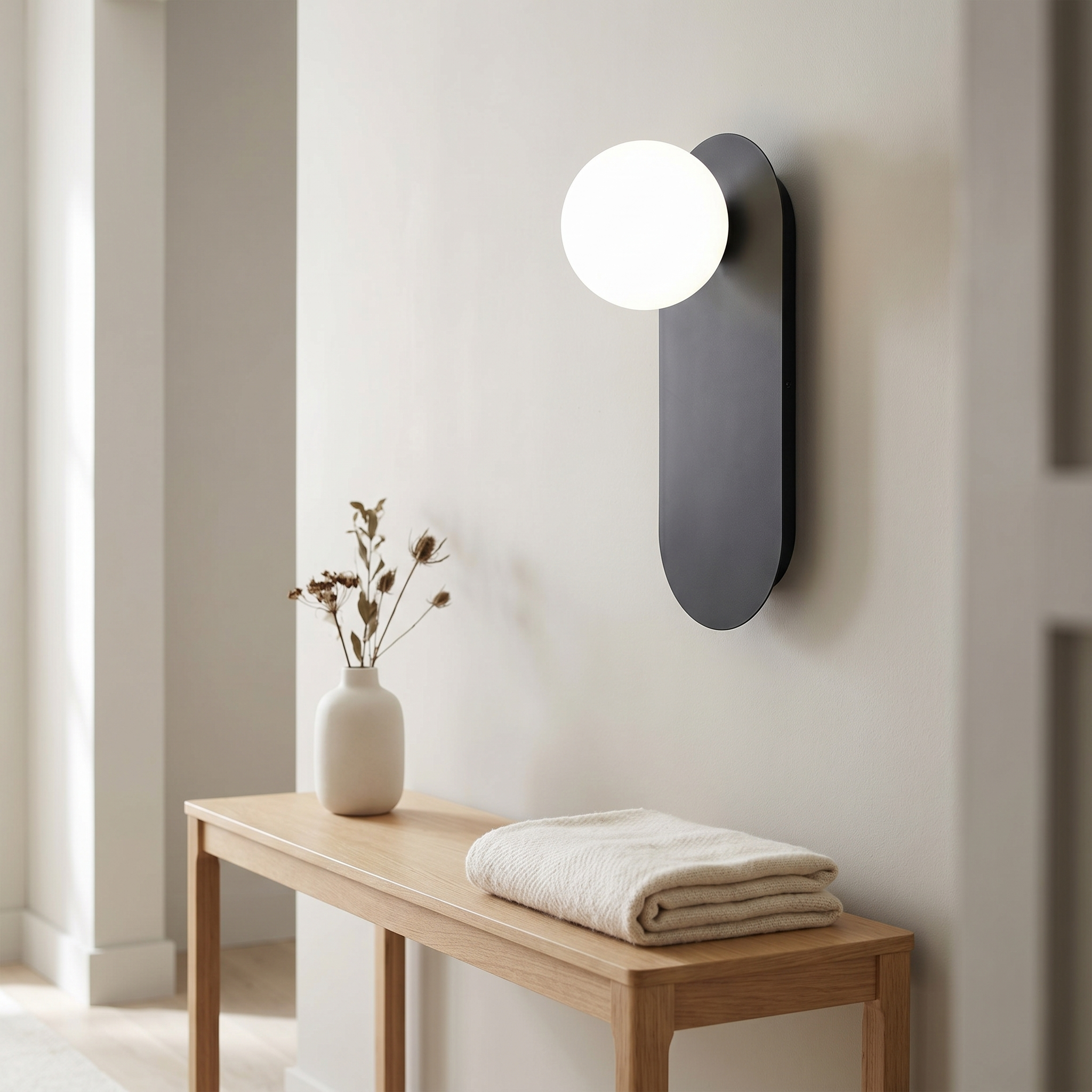 Black Sfera Lucente wall sconce with neutral 4000K glow in a modern entryway