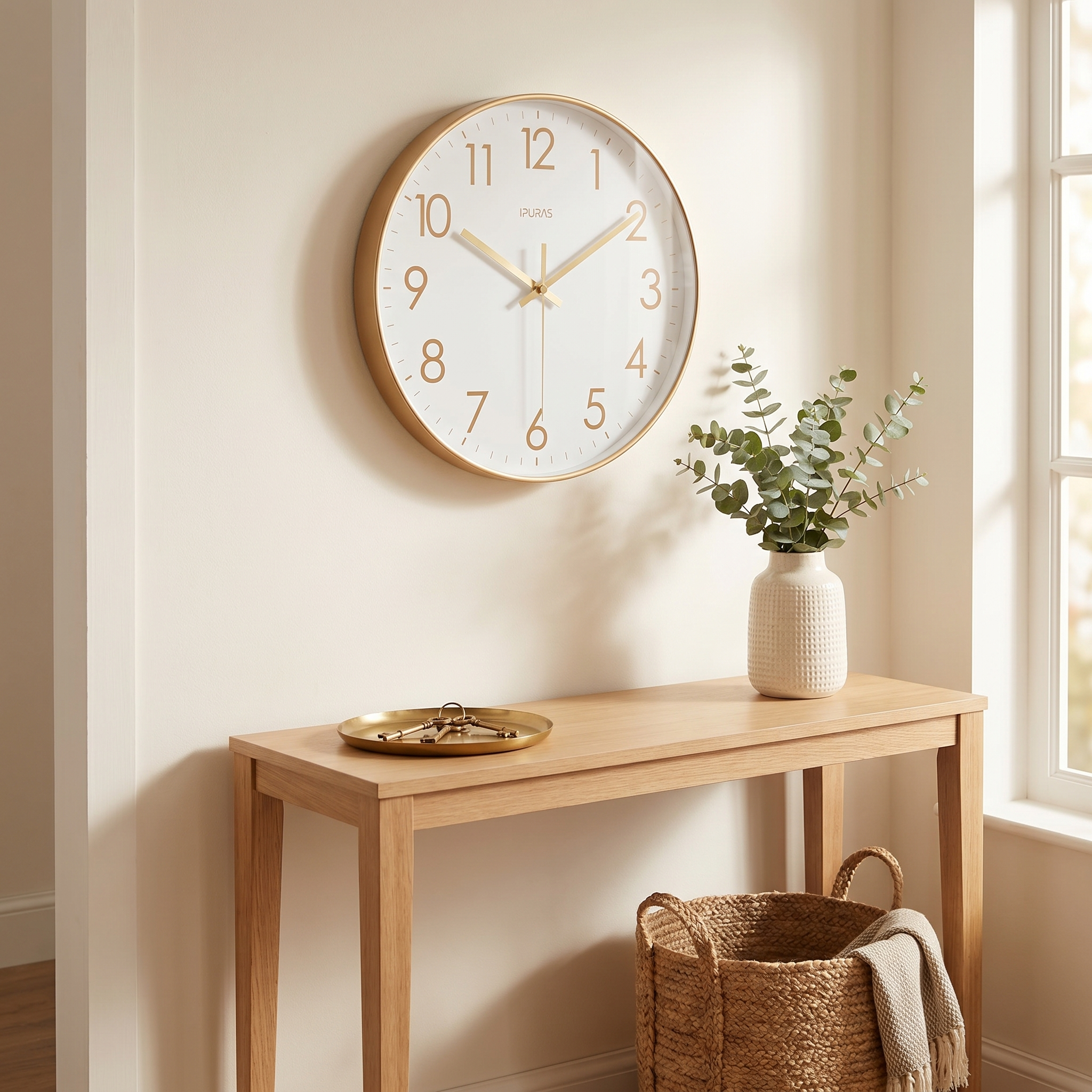 Gold Nordic wall clock above an entryway console with eucalyptus