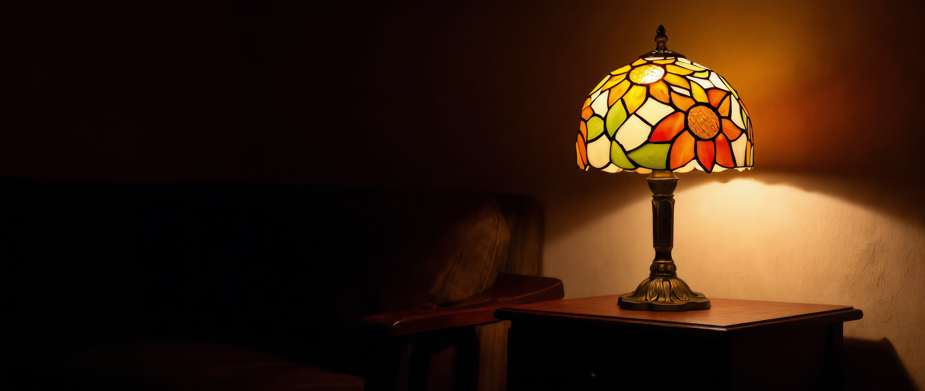 Fiori di Vetro stained glass Tiffany table lamp glowing warm in a cozy interior, widescreen banner