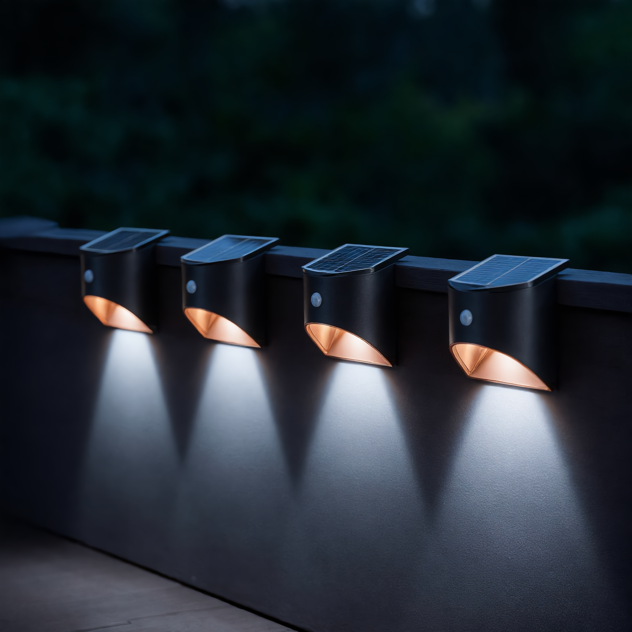 Four black Stella Solare solar wall lights along a deck railing with cool white glow