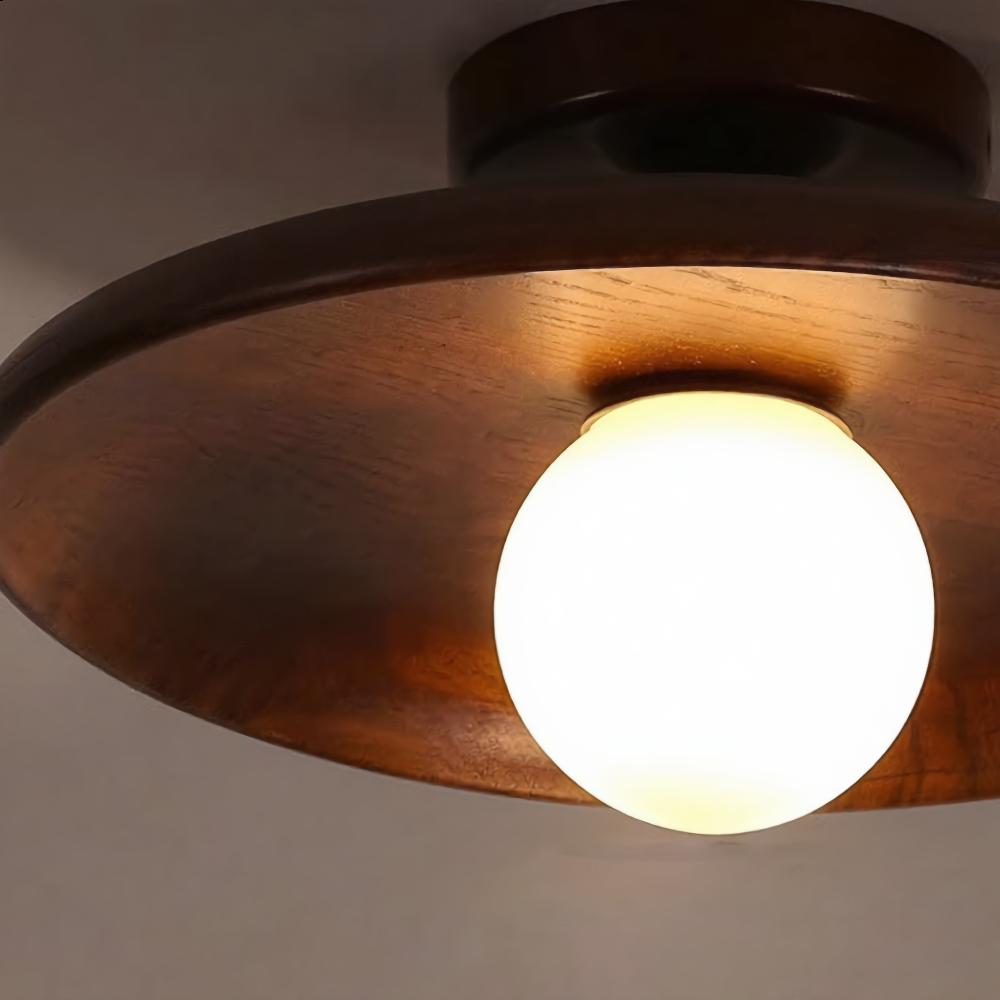 Close-up macro of the Aureola walnut ceiling light frosted glass globe and wood grain