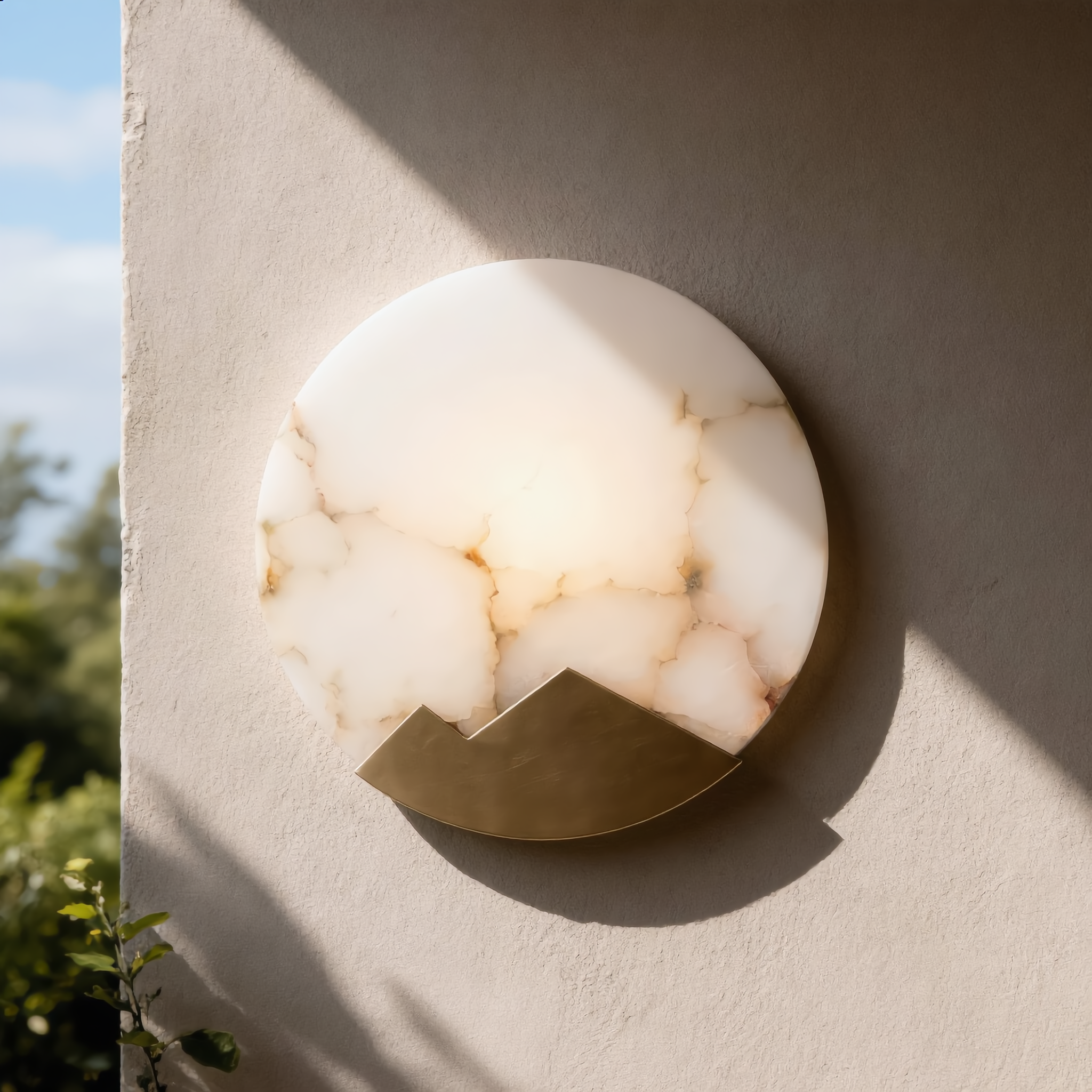 Luna d'Alabastro alabaster wall sconce in daylight showing its natural marble veining and copper