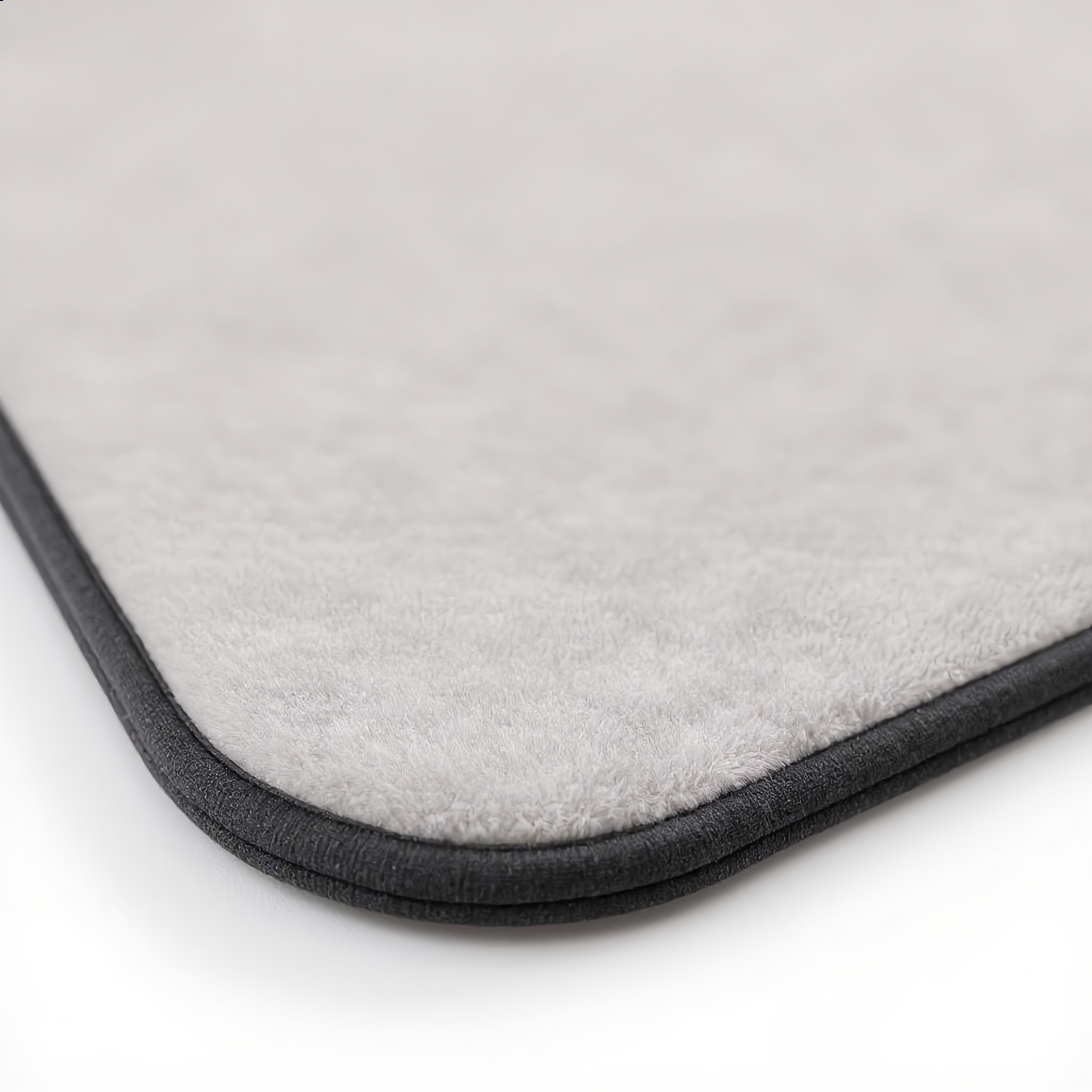Macro close-up of the smooth micro suede surface and dark edge trim