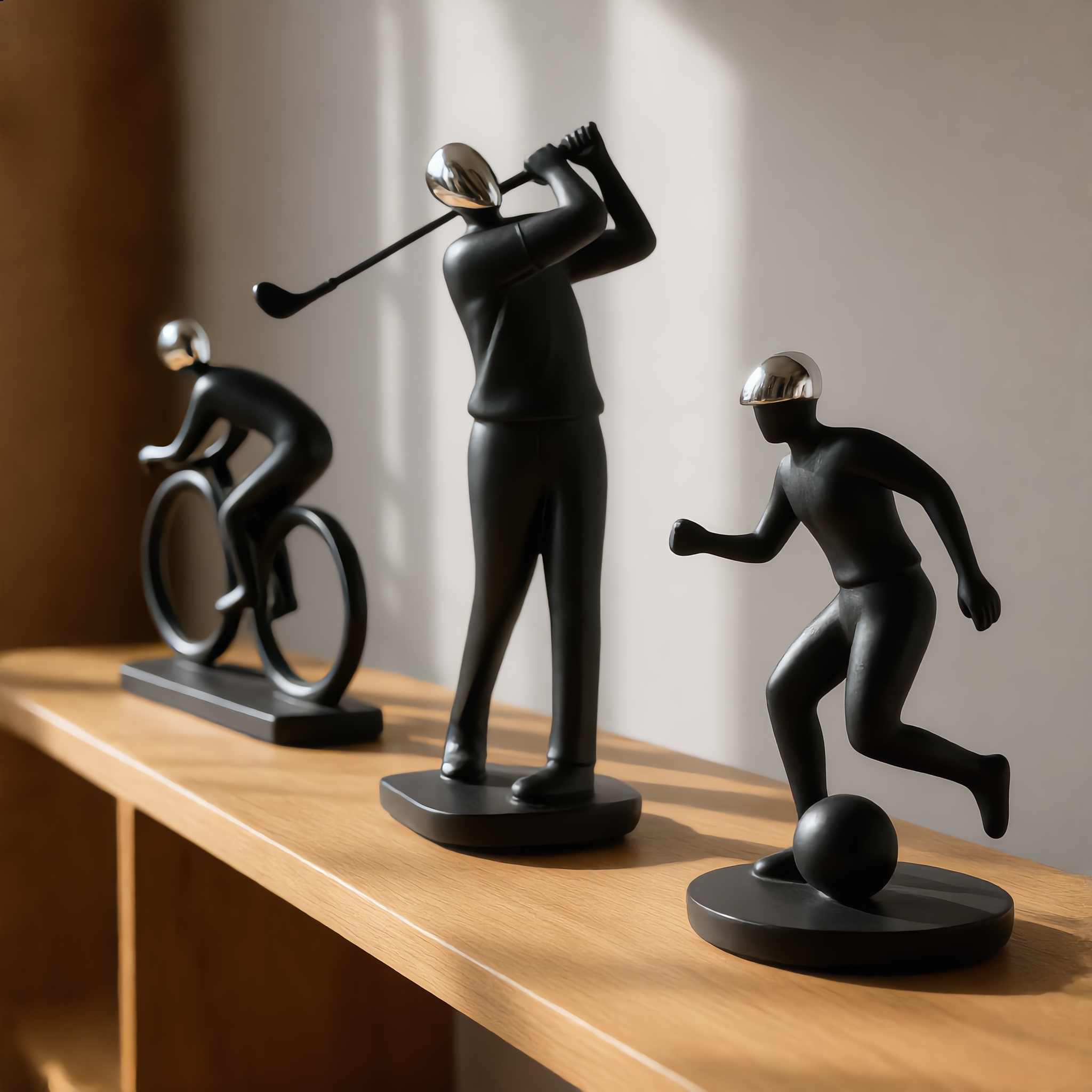 Three black resin sports sculptures displayed together on a shelf