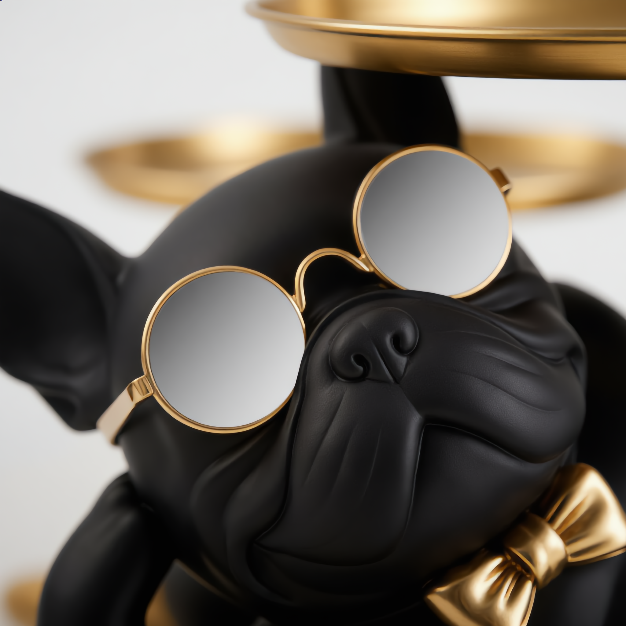 Close-up of black lounging bulldog statue face with round sunglasses and gold bow tie