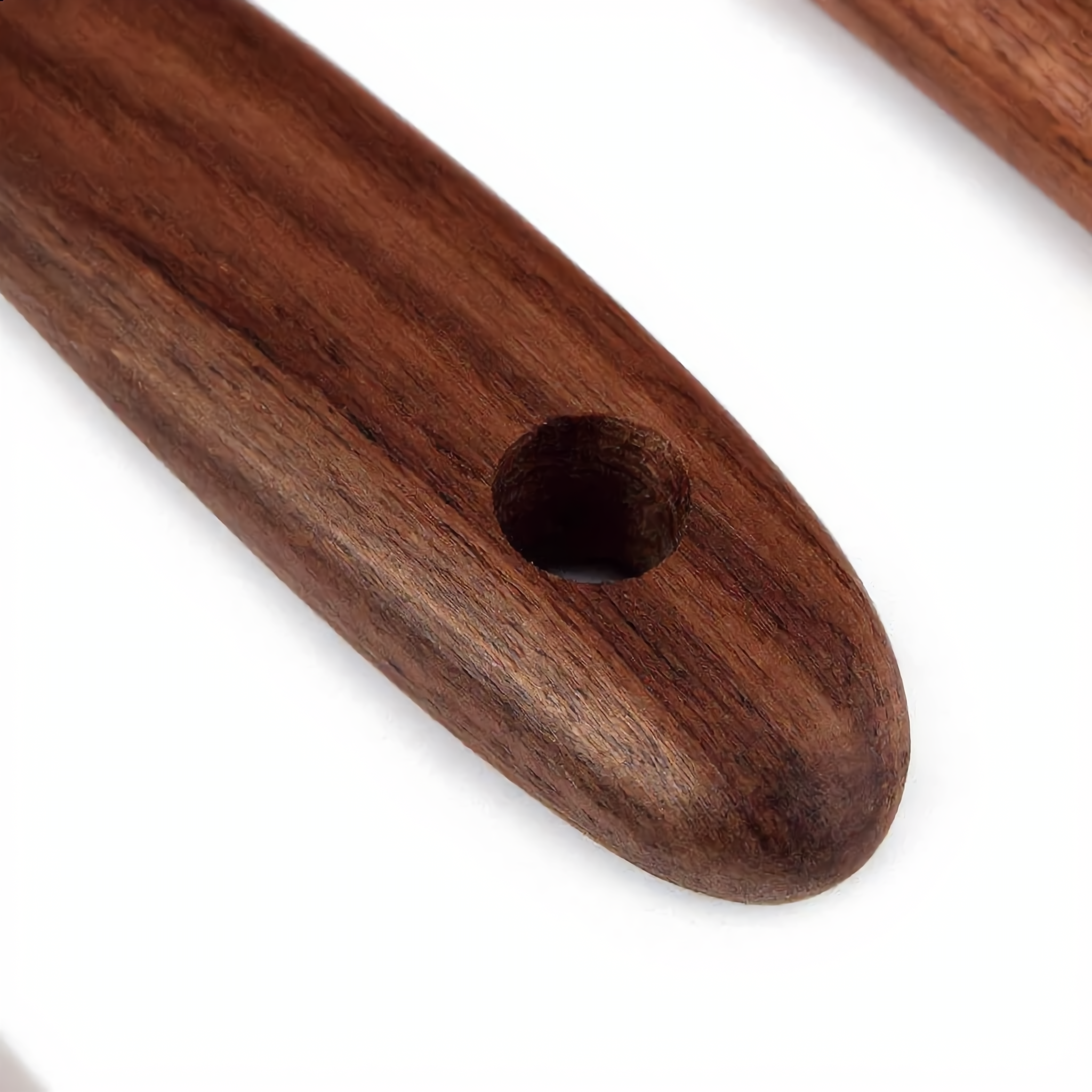 Close-up of a teak utensil handle with its hanging hole