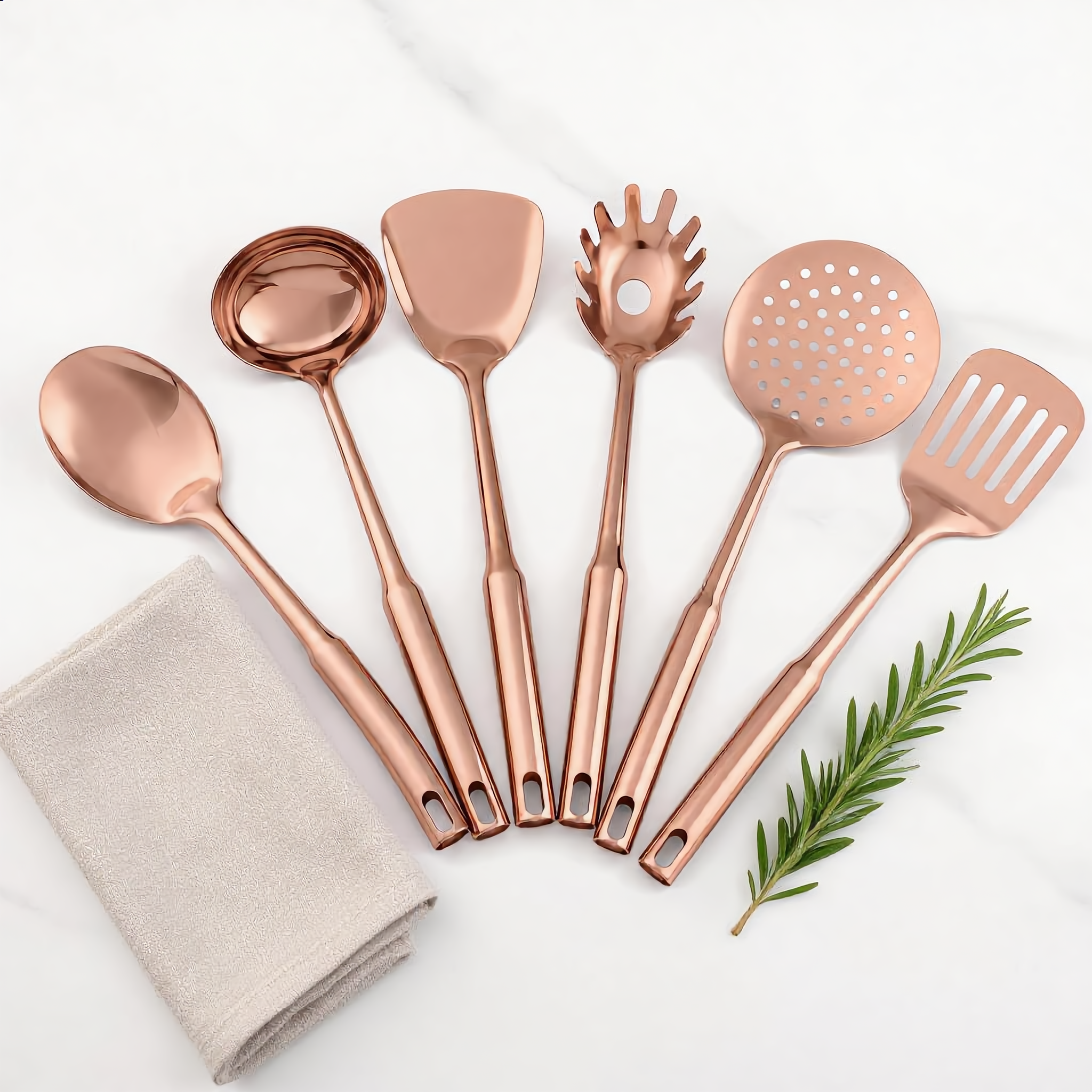 Rose Gold Aurora utensils flat-lay on marble with linen and rosemary