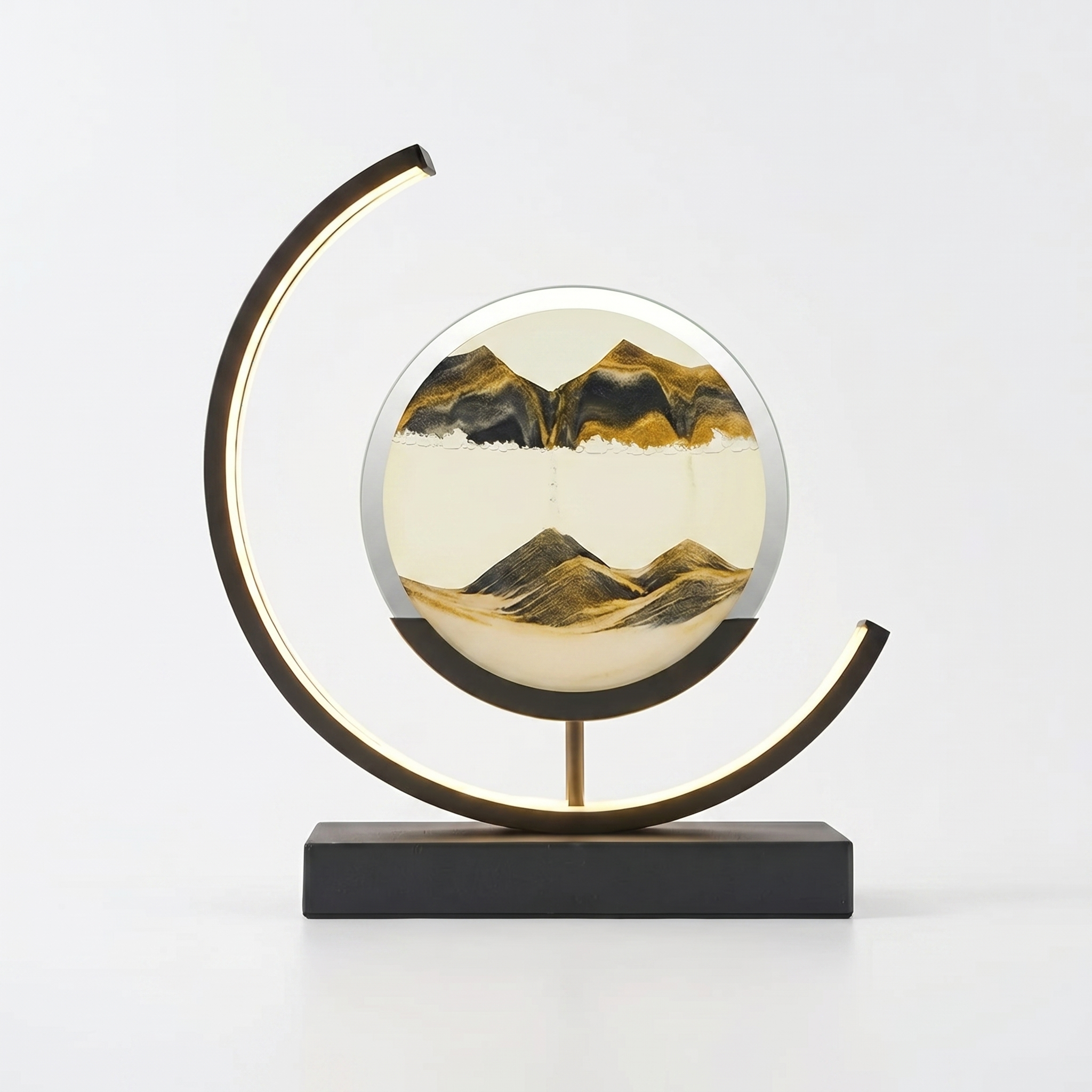 Duna moving sand art lamp with black and gold sandscape, glowing, on white