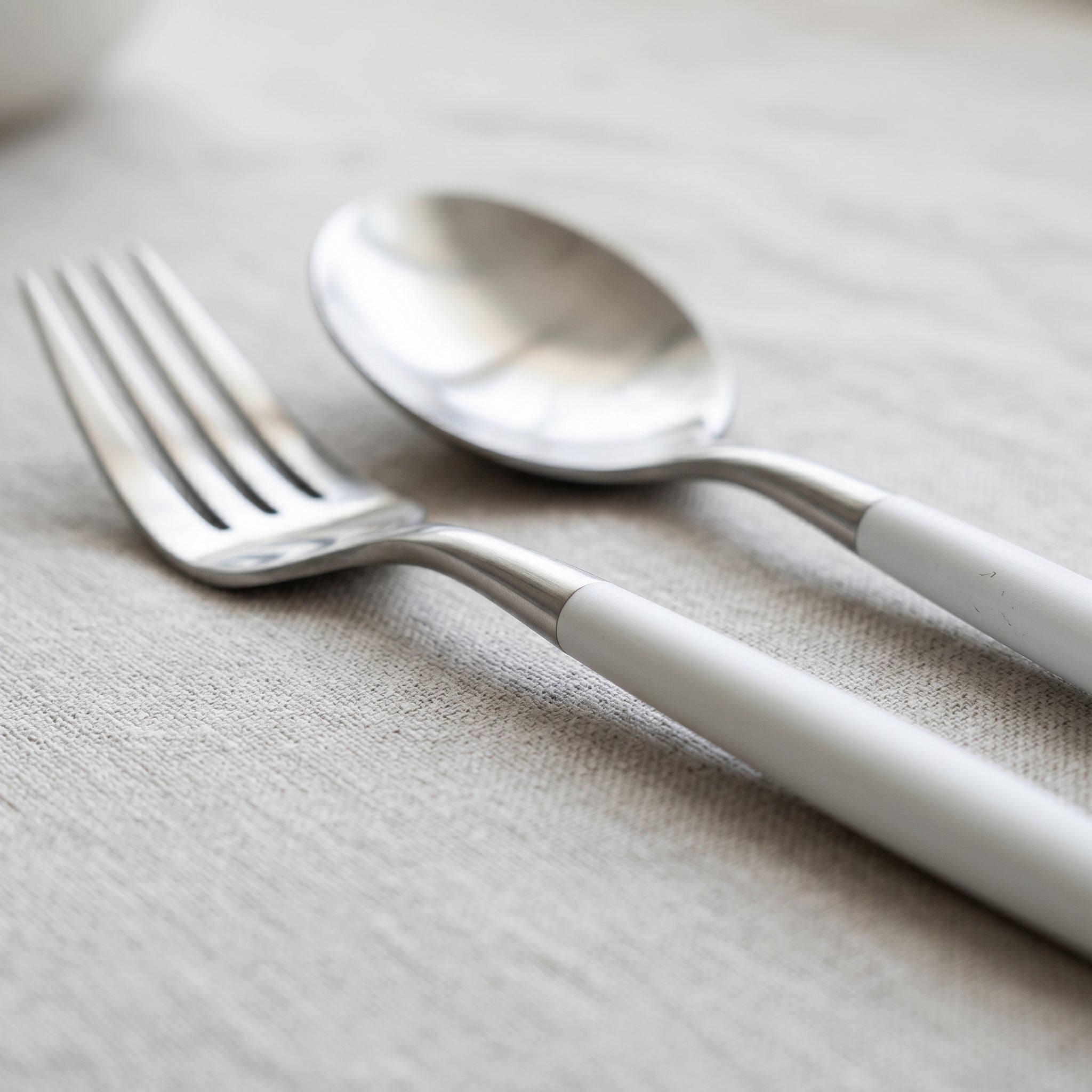Close-up of white and silver fork and spoon showing the mirror finish
