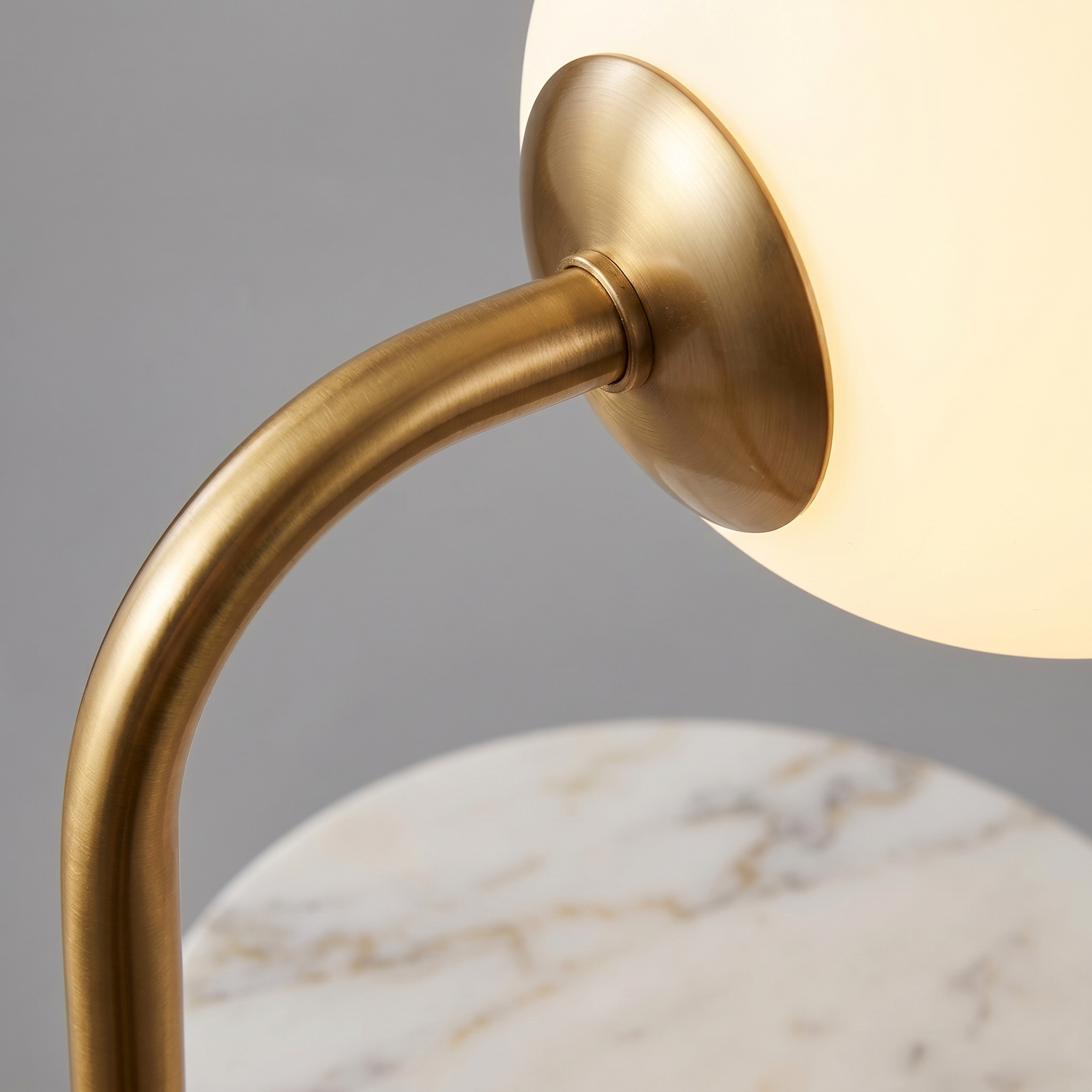 Macro of the opal glass globe, brass frame and white marble table edge