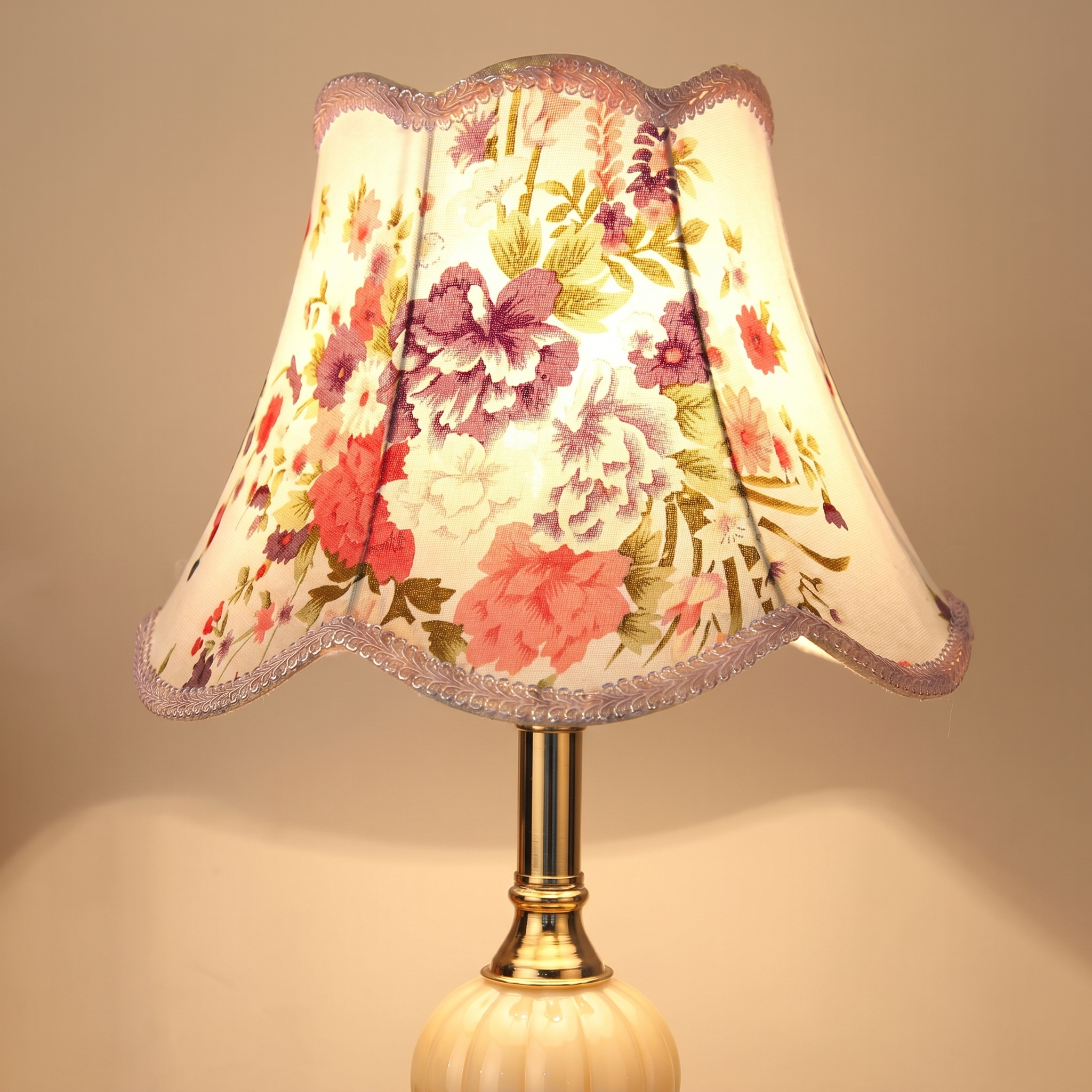 Macro of the floral fabric shade, opal glass orb and gold base detail