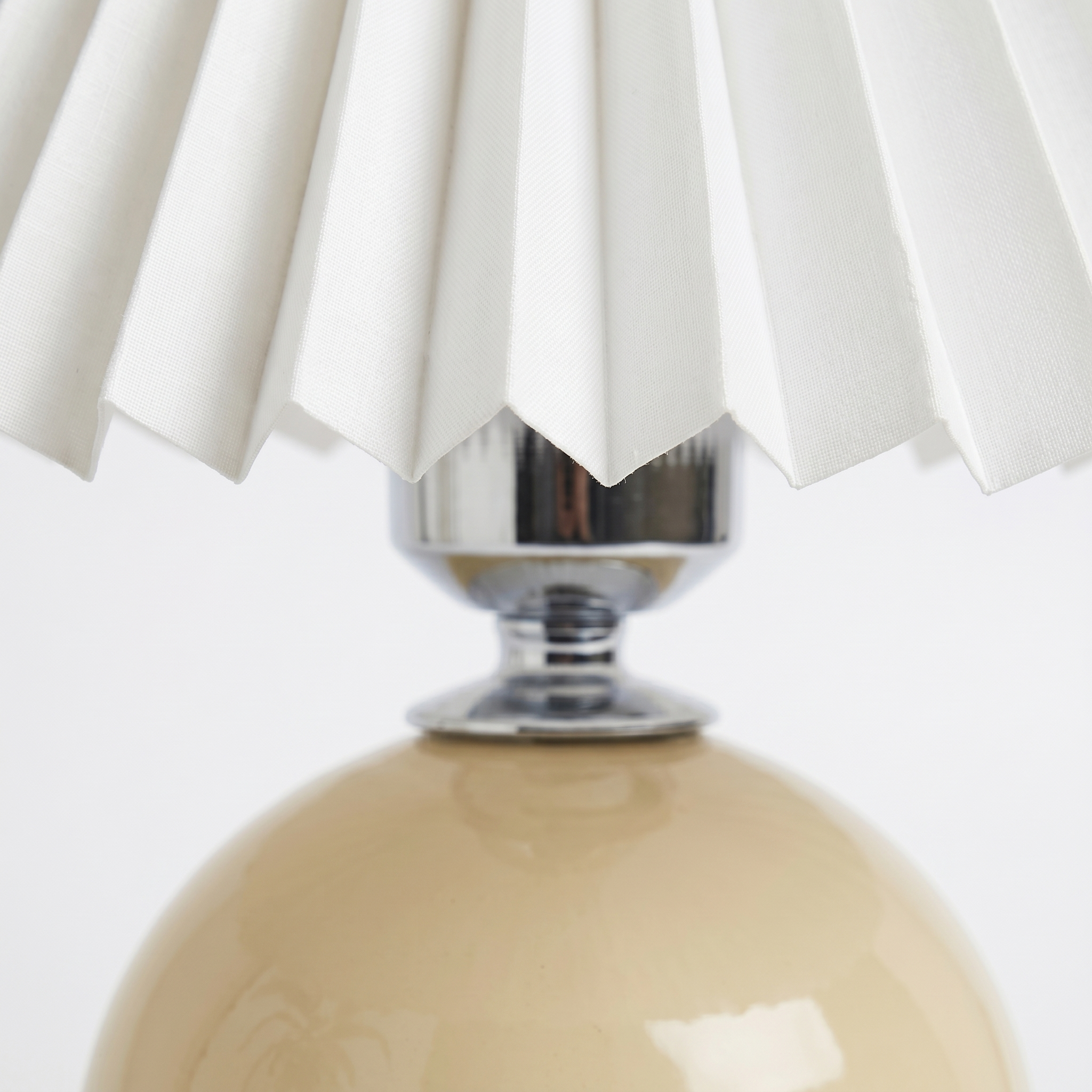 Close-up of the pleated fabric shade and ceramic base