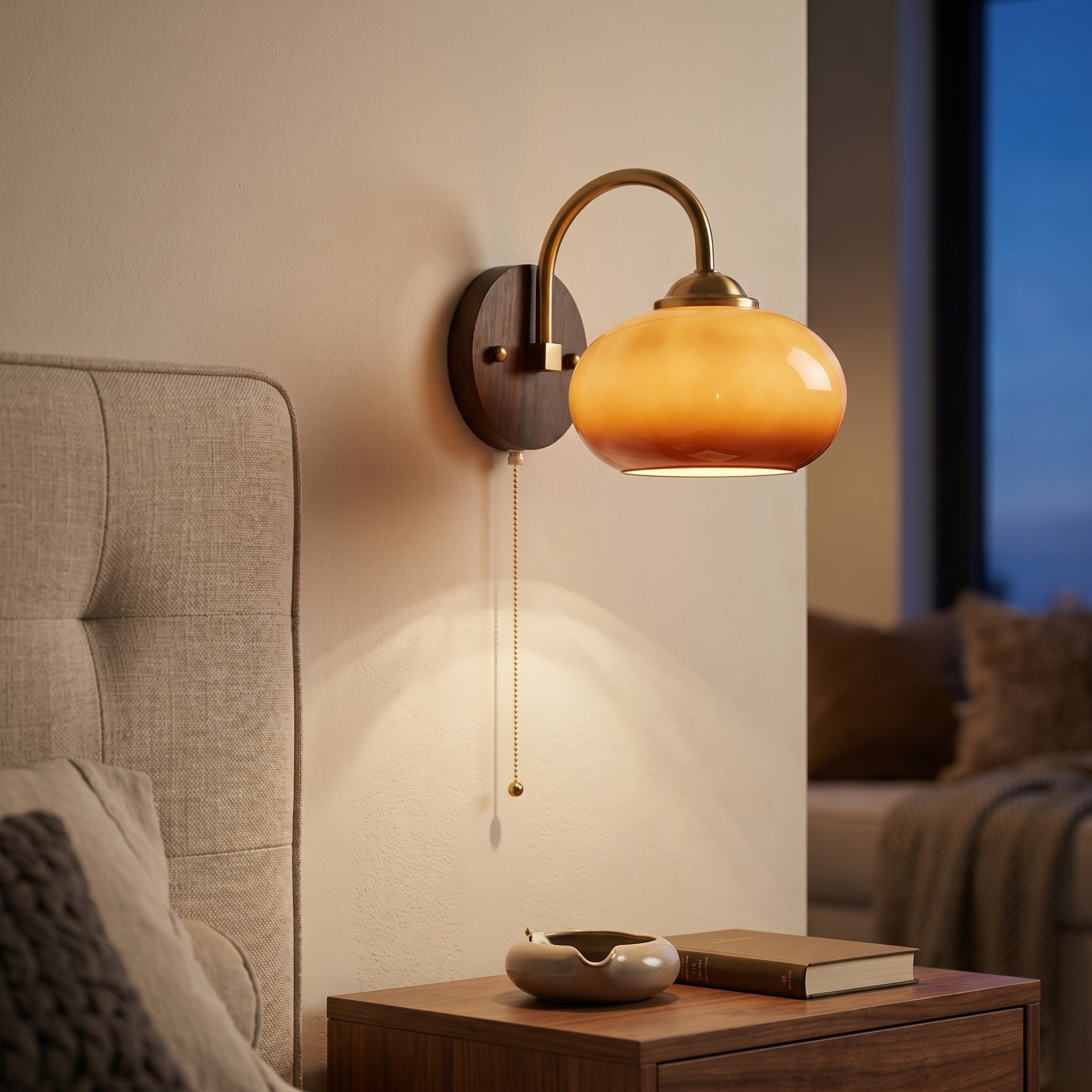 Oval caramel Tramonto sconce glowing above a bedside table