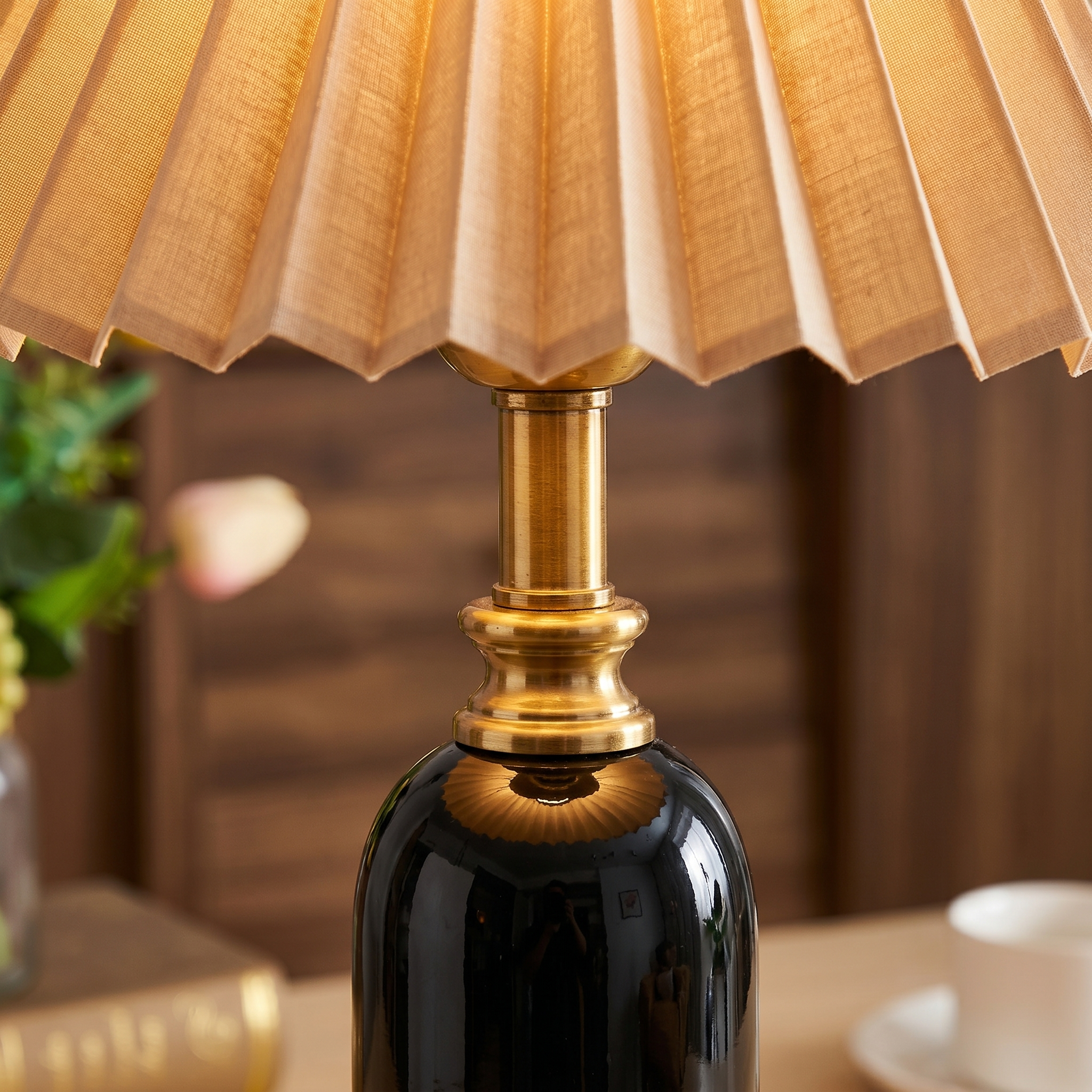 Close-up of the Camelia pleated shade, brass neck and ceramic body