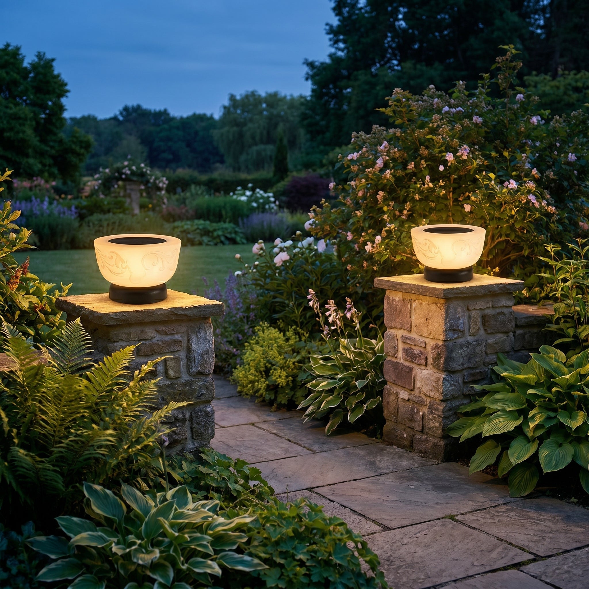 Sera Dorata solar pillar lights glowing on stone garden pillars flanking a path at dusk
