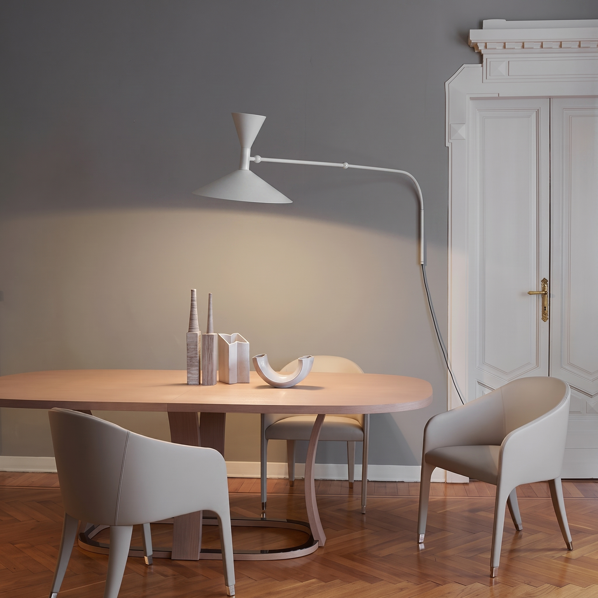 White swing-arm wall lamp over a dining table