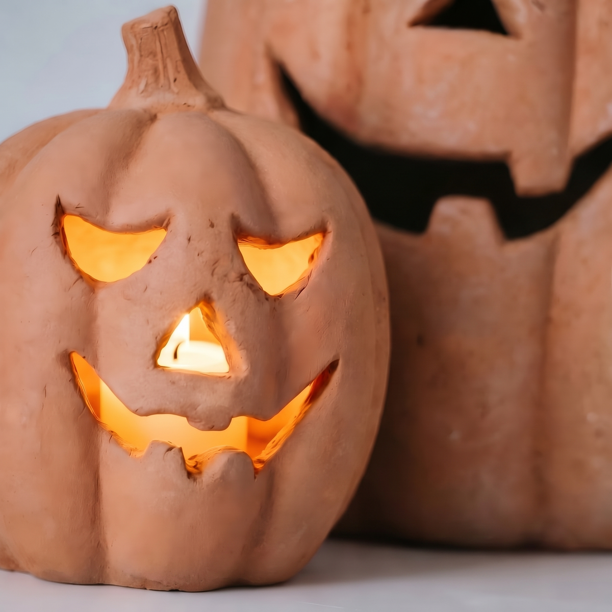 Close-up of the carved glowing face of a Zucca Toscana terracotta pumpkin