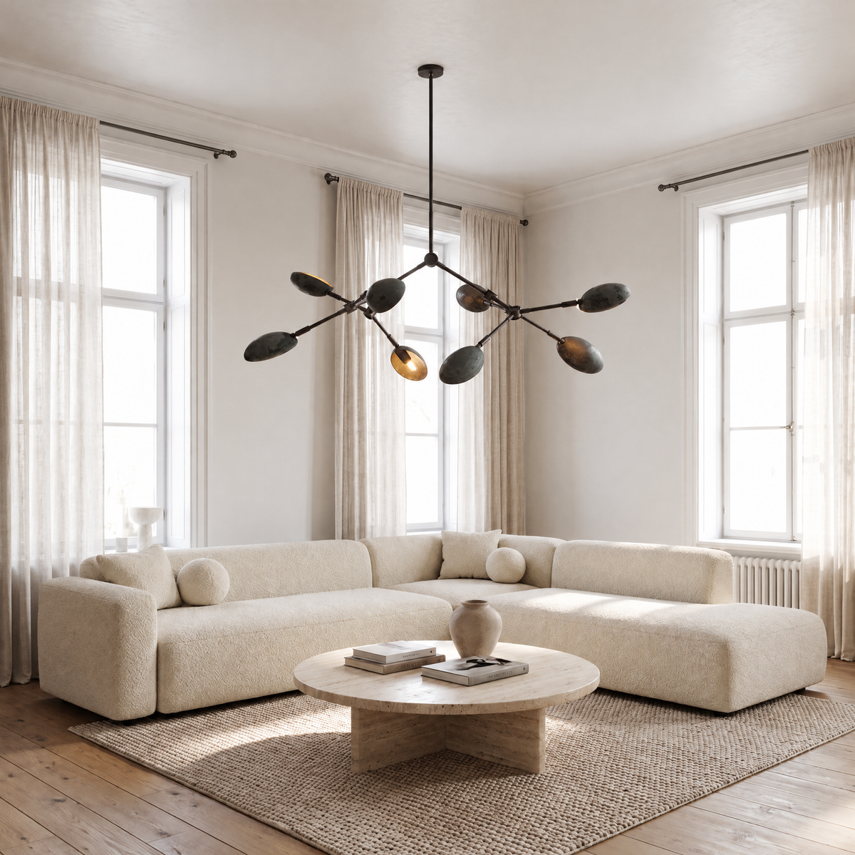 Ramo Goccia oxidized branch chandelier above a coffee table in a bright living room
