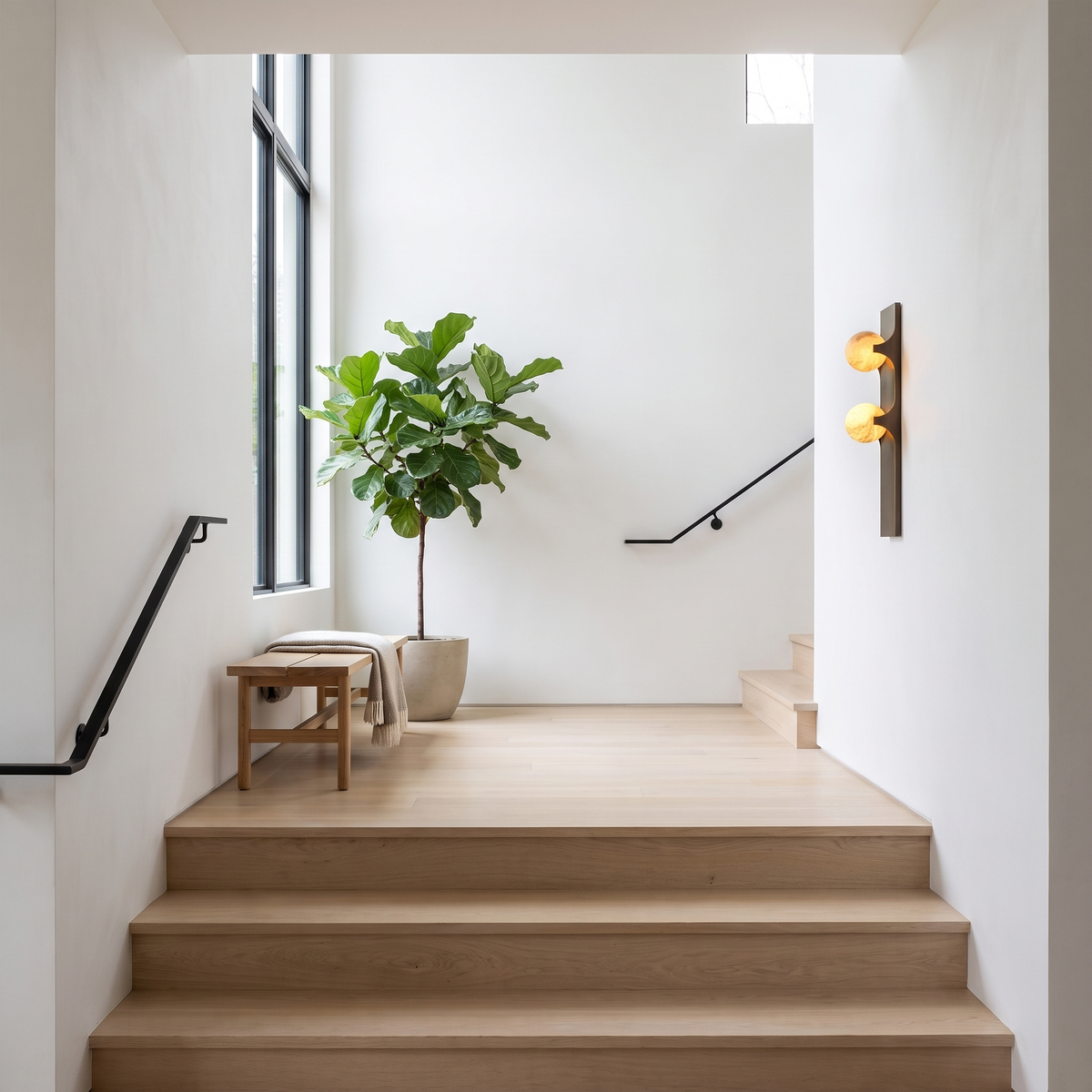 Brass and alabaster wall sconce on a bright staircase landing
