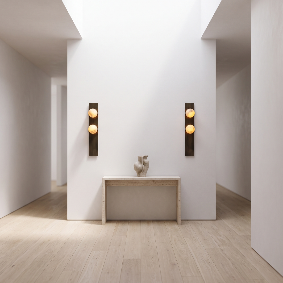 Brass double alabaster wall sconces flanking a travertine console in a bright gallery hallway