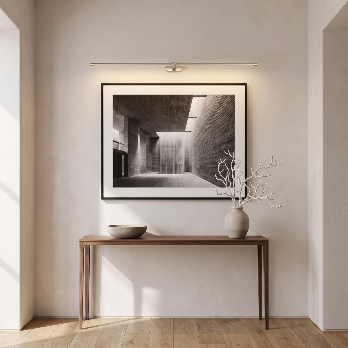 Nickel cordless picture light above a black and white photograph in a hallway