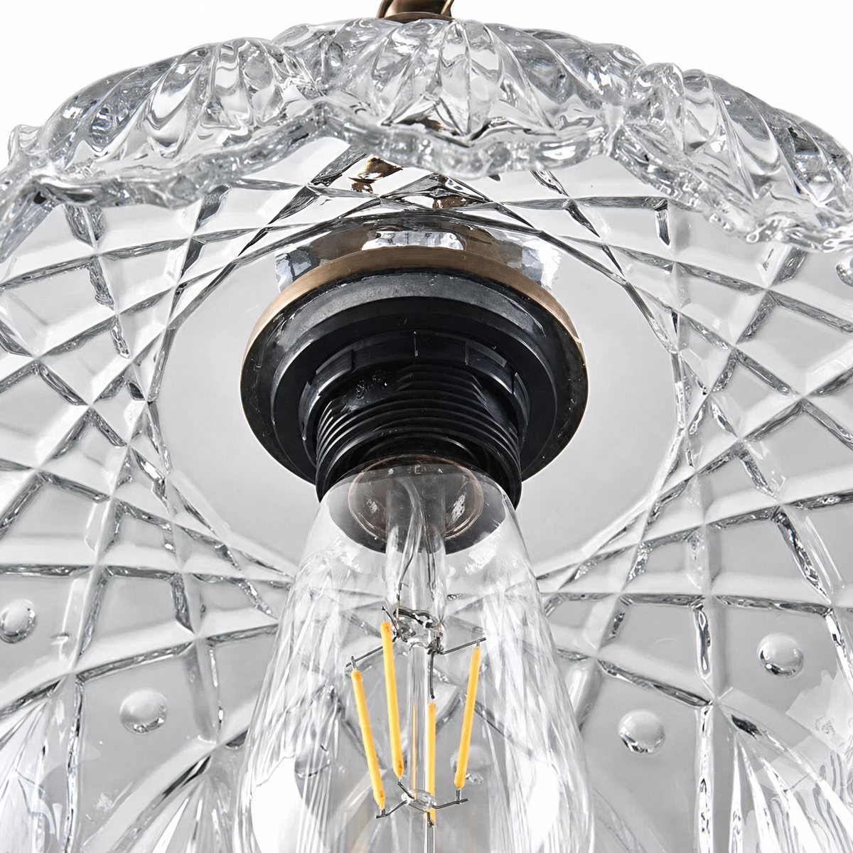 View up into the carved glass shade showing the E26 socket and bulb