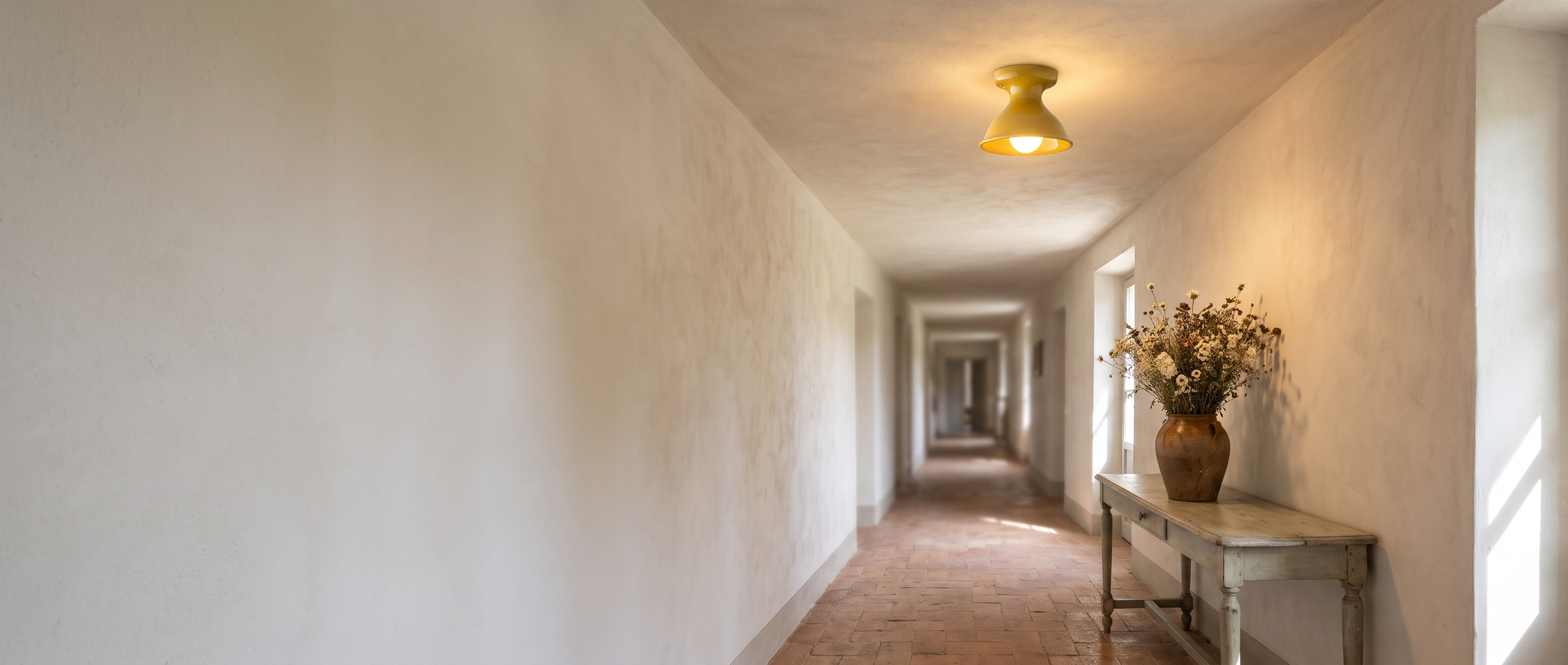 Chamomile yellow ceramic flush mount ceiling light in a sunlit Italian villa hallway