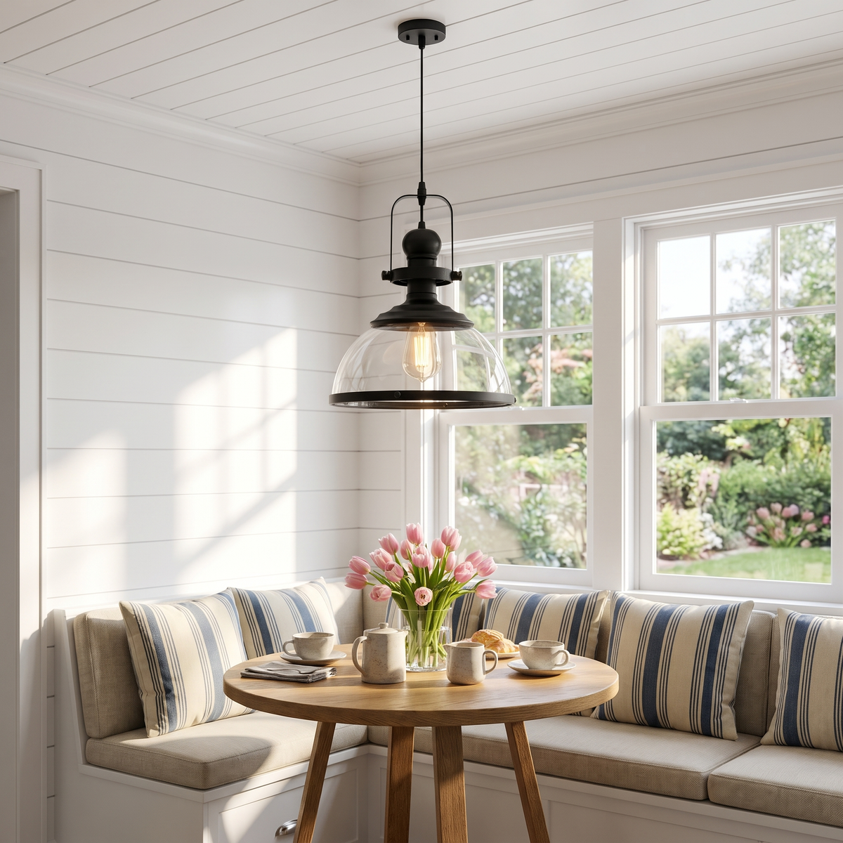 Clear glass dome pendant light above a sunlit breakfast nook