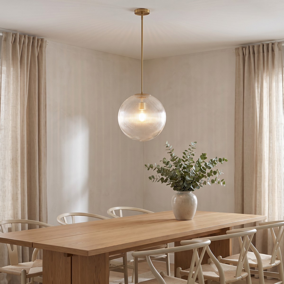 Rigata 16 in brass ribbed glass globe pendant over a Scandinavian dining table