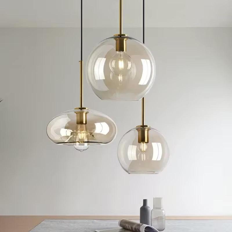 Cluster of Ambra cognac glass pendant lights in mixed shapes