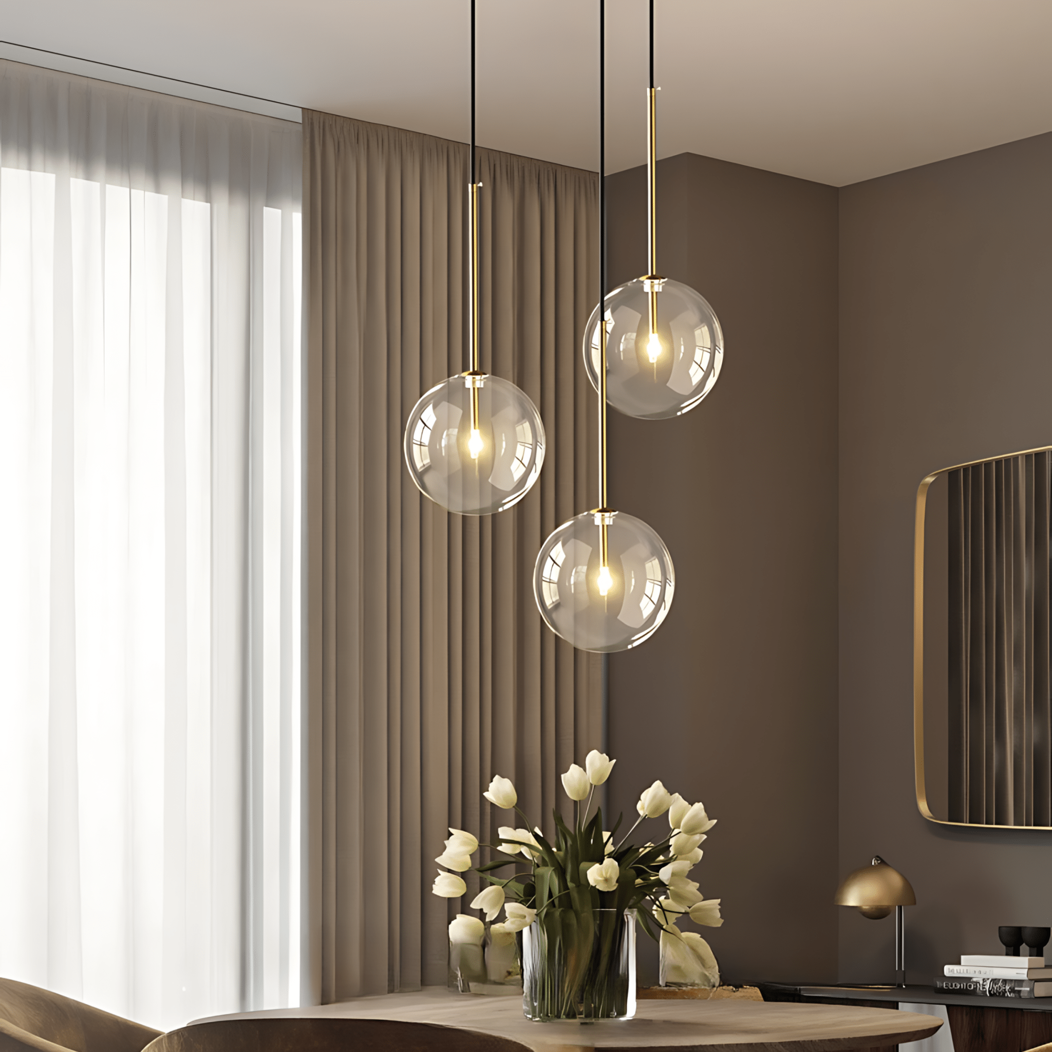 Three brass Goccia clear glass ball pendants over a dining table with tulips