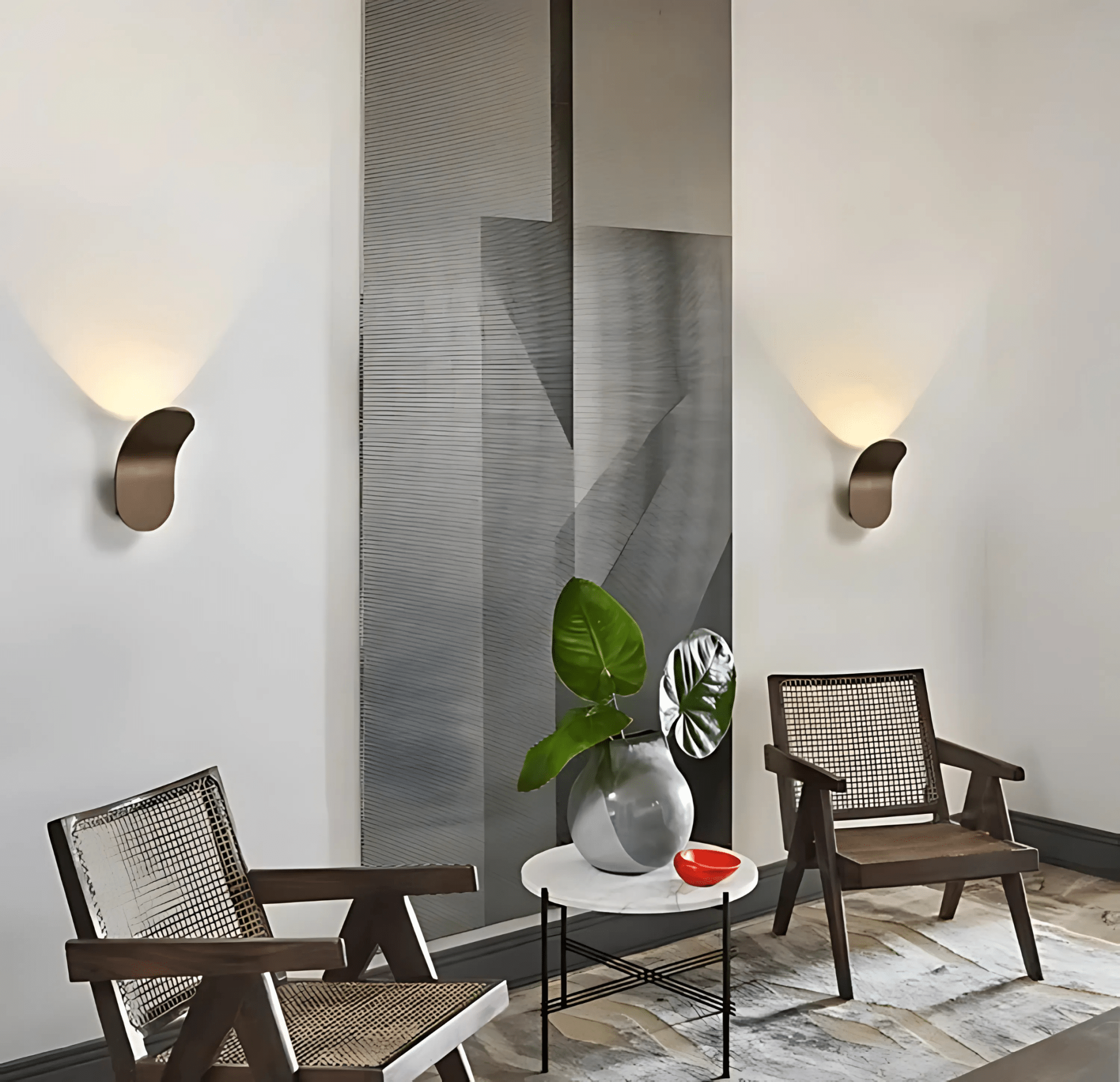 Bronze curved wall sconces in an elegant sitting room with cane chairs